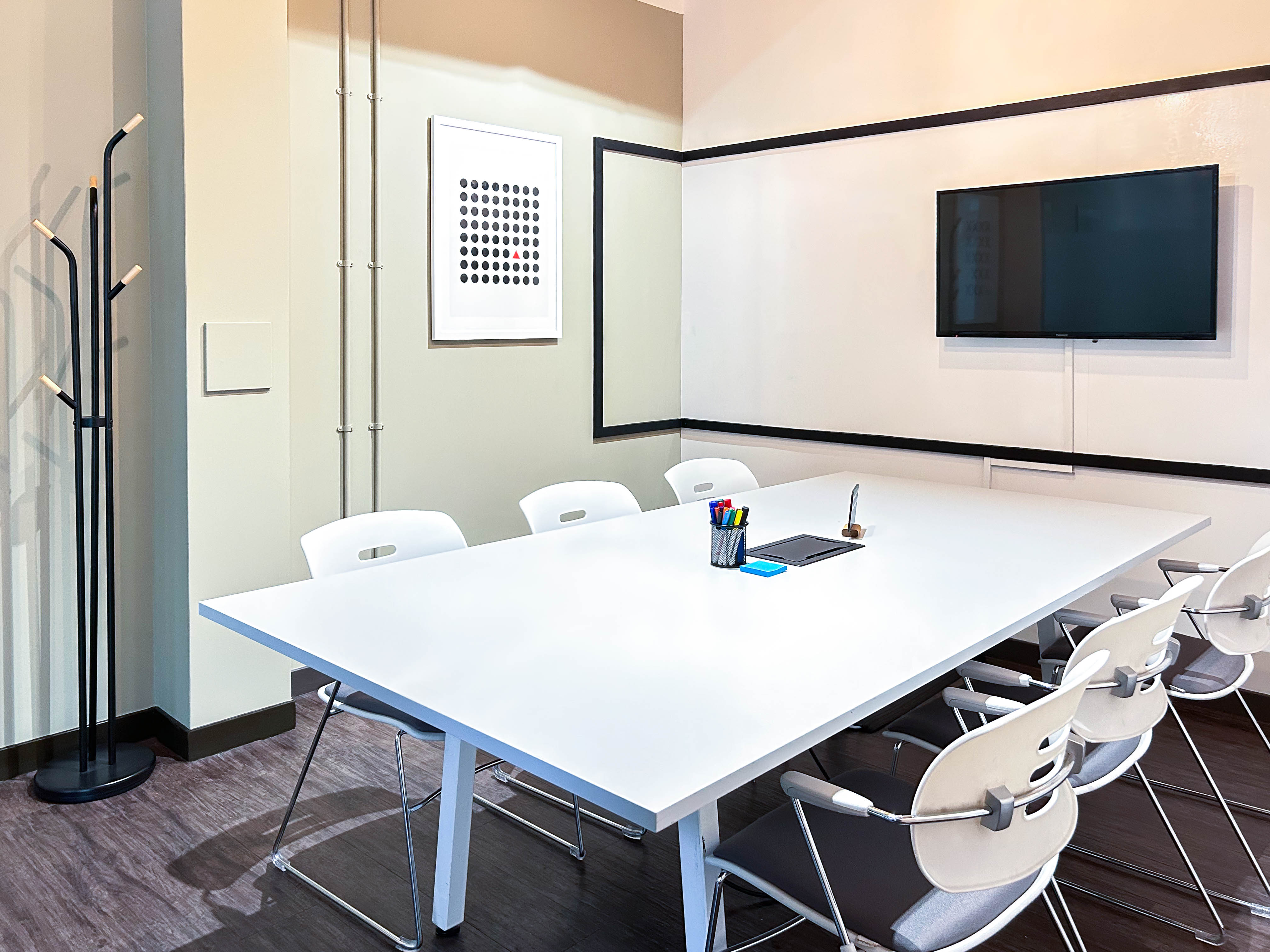 Modern meeting room with white table, ideal for collaborative discussions and presentations.