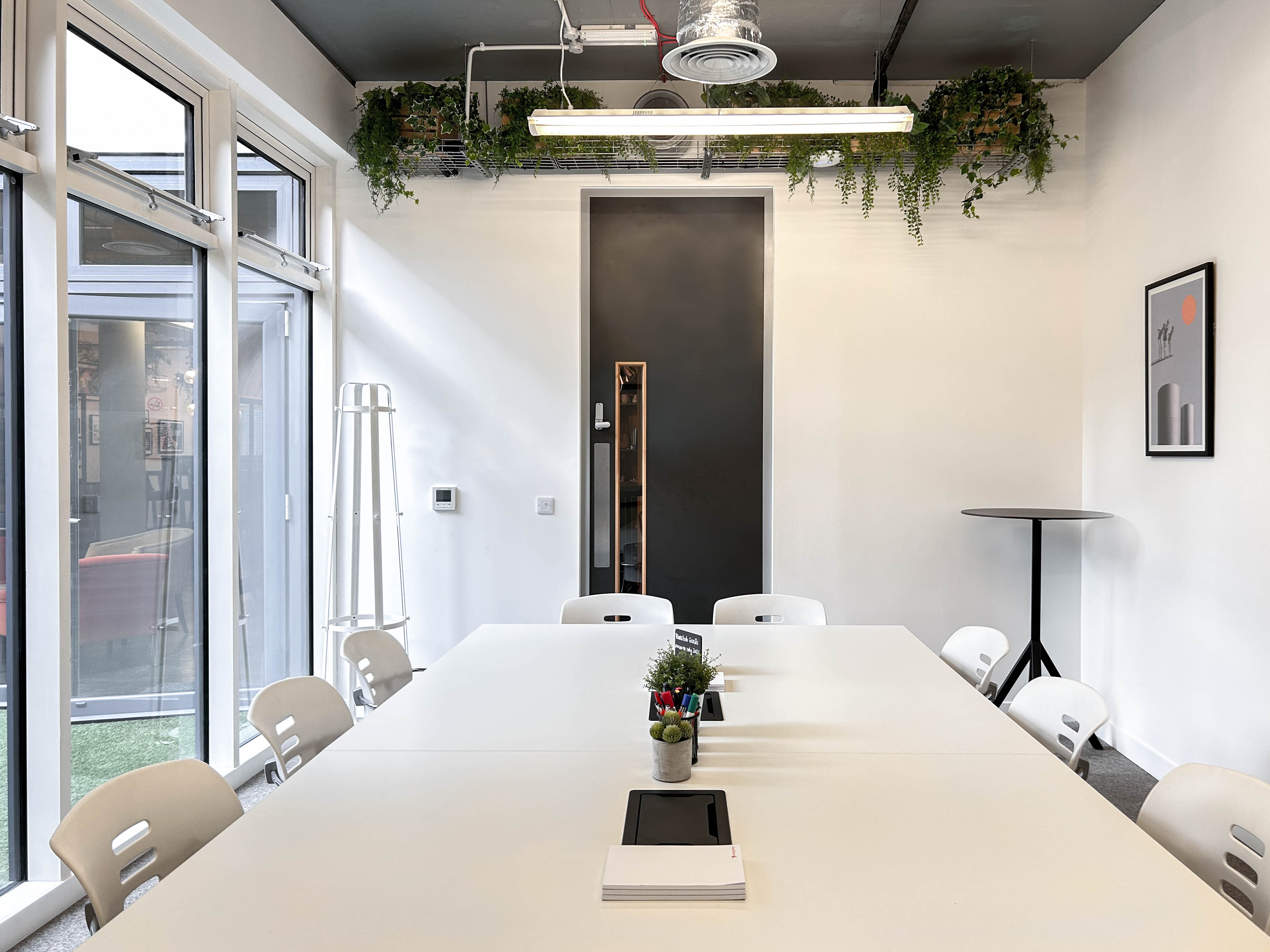 Modern meeting room with large white table, ideal for collaborative sessions.