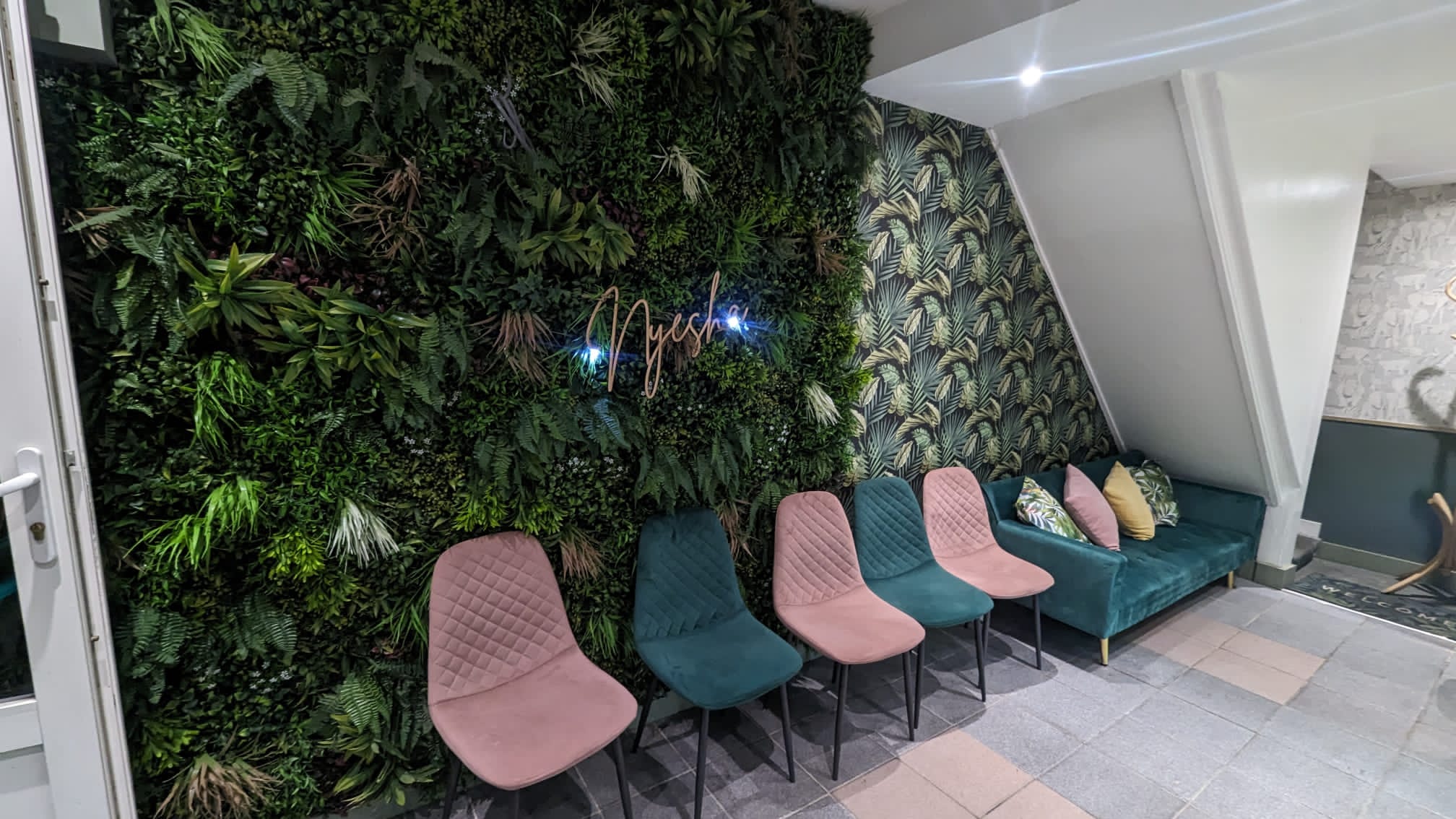 Stylish Railton Lounge waiting area with lush green wall, perfect for meetings and events.
