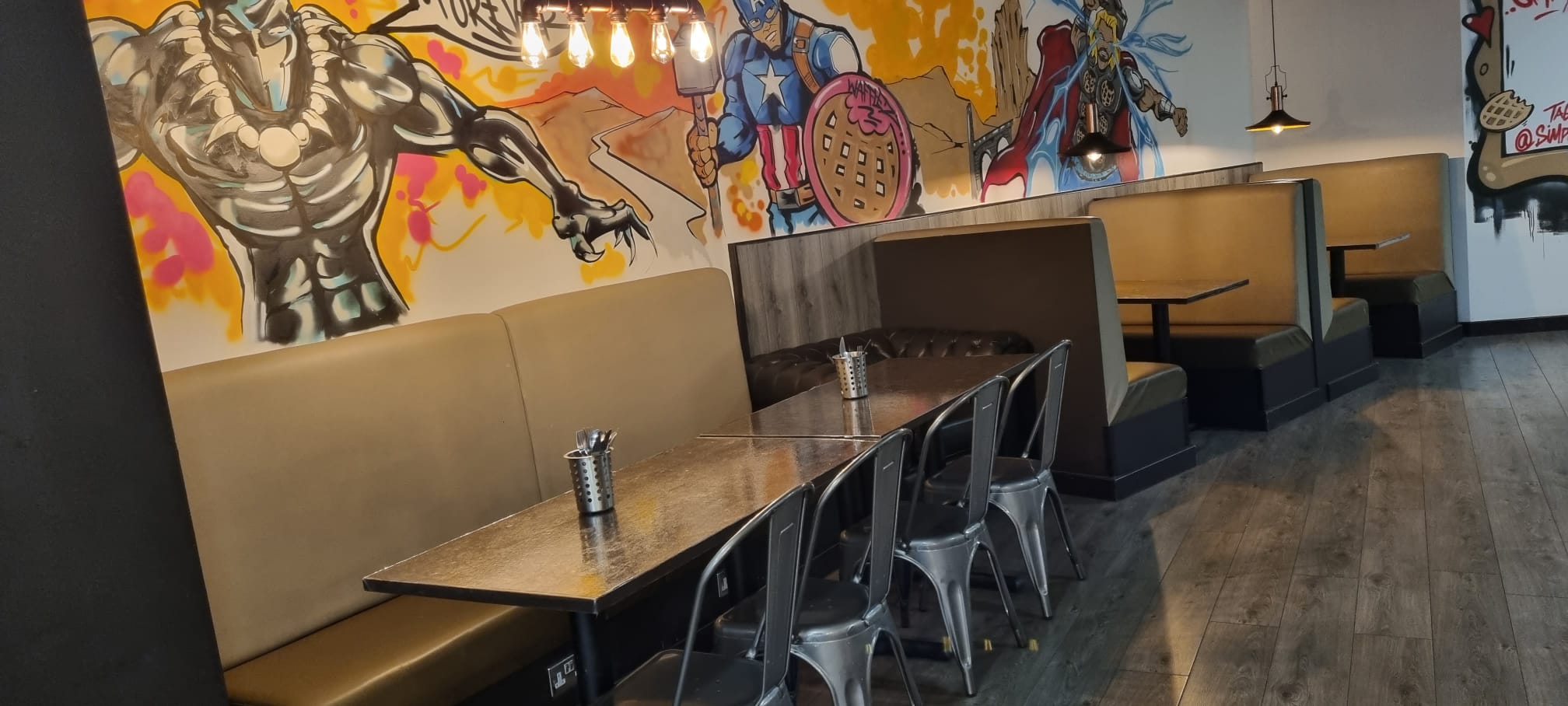 Vibrant dining space with superhero murals for casual meetings and team-building events.