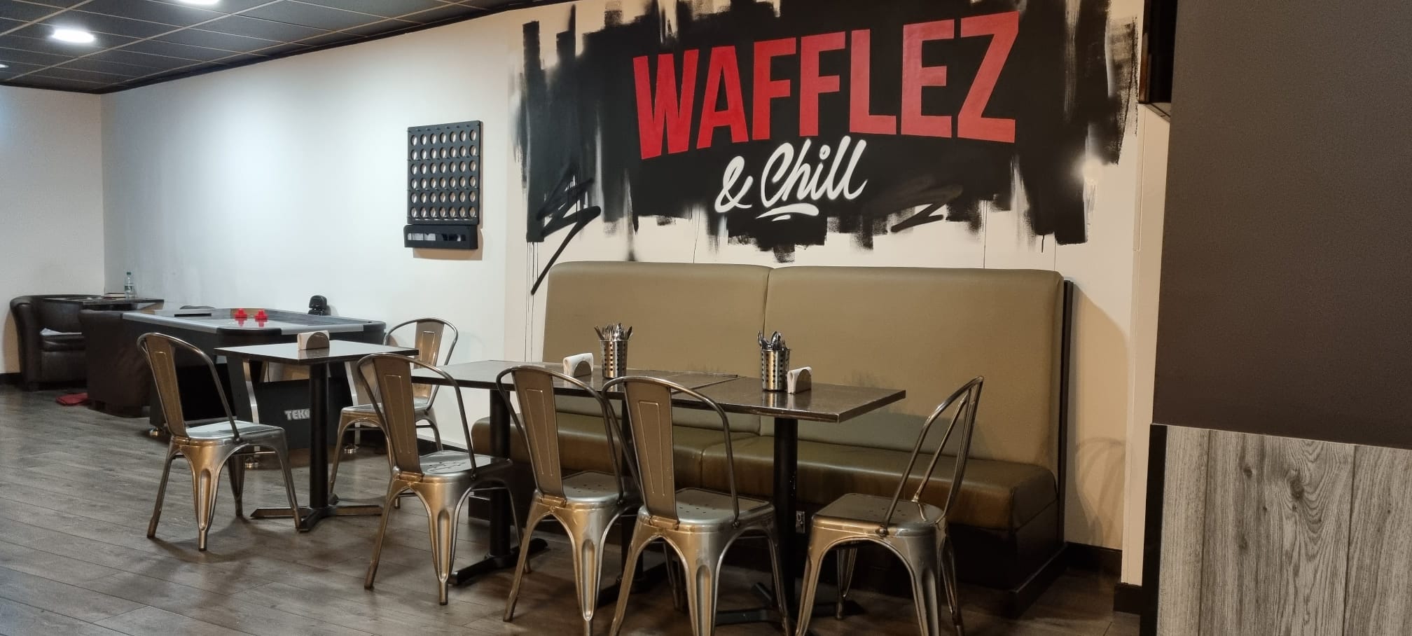 Trendy dining space with "WAFFLEZ & Chill" mural for casual meetings and events.