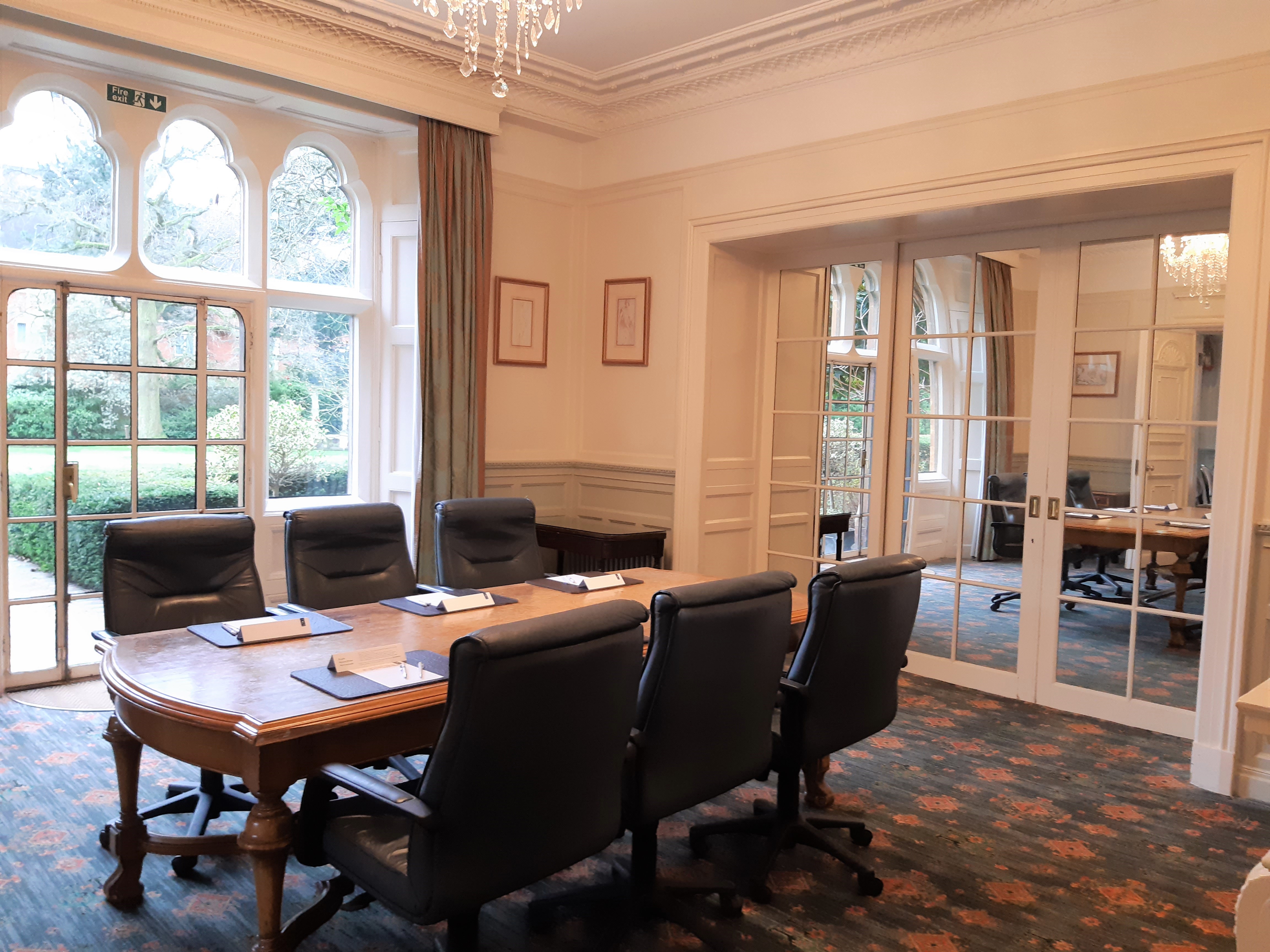 Lilac meeting room at Warren House Hotel with wooden table, ideal for corporate events.