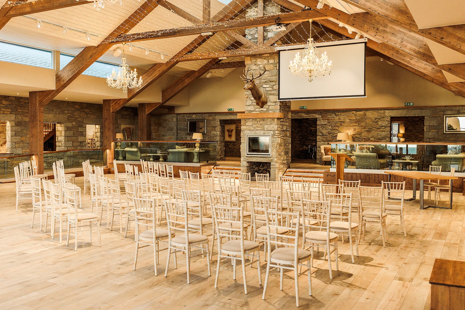 Elegant event space with wooden beams, perfect for presentations and ceremonies.