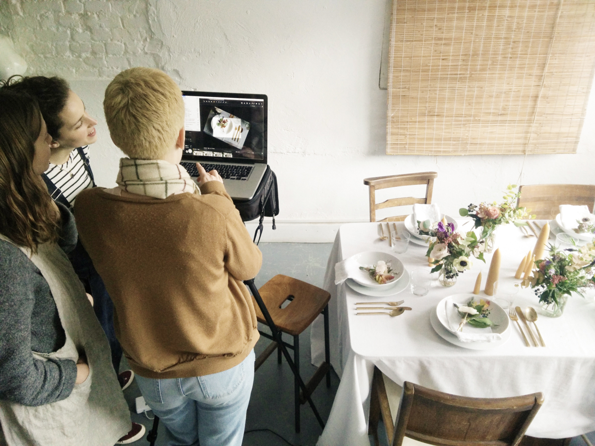 Event professionals reviewing elegant dining setup at North London Green Photographic Studio.