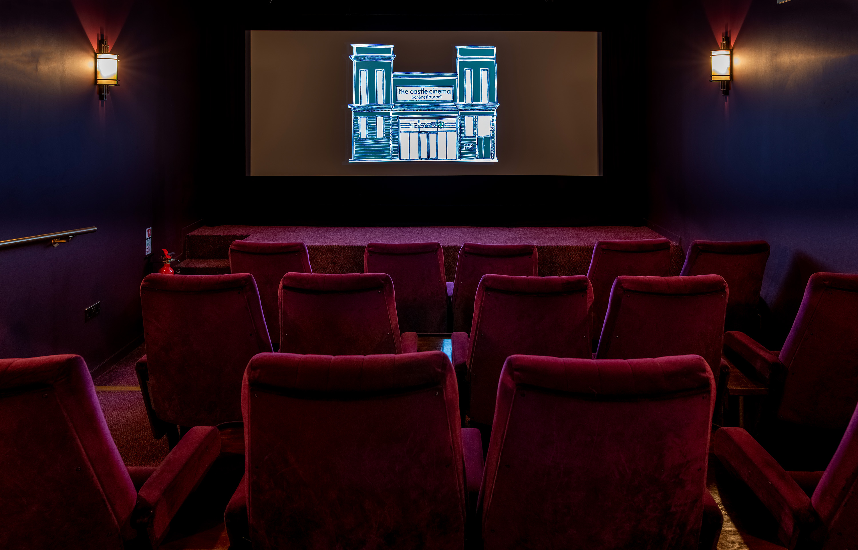 Cozy screening room with plush red seating for private film events and corporate meetings.