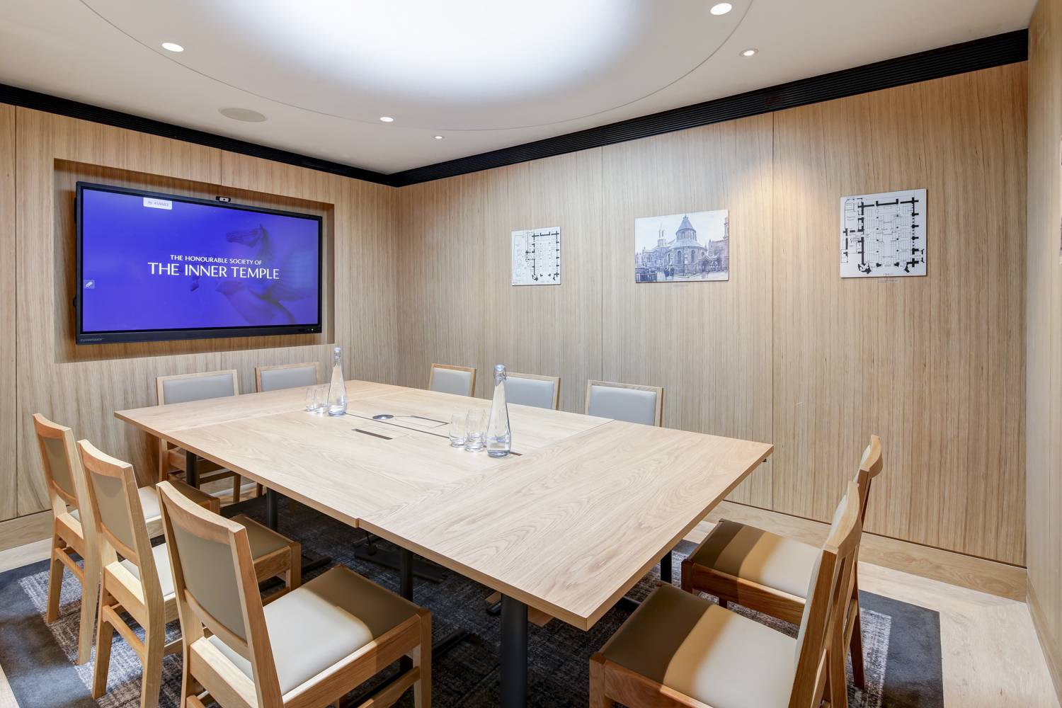 Modern meeting room with wooden table, ideal for strategy sessions and small conferences.