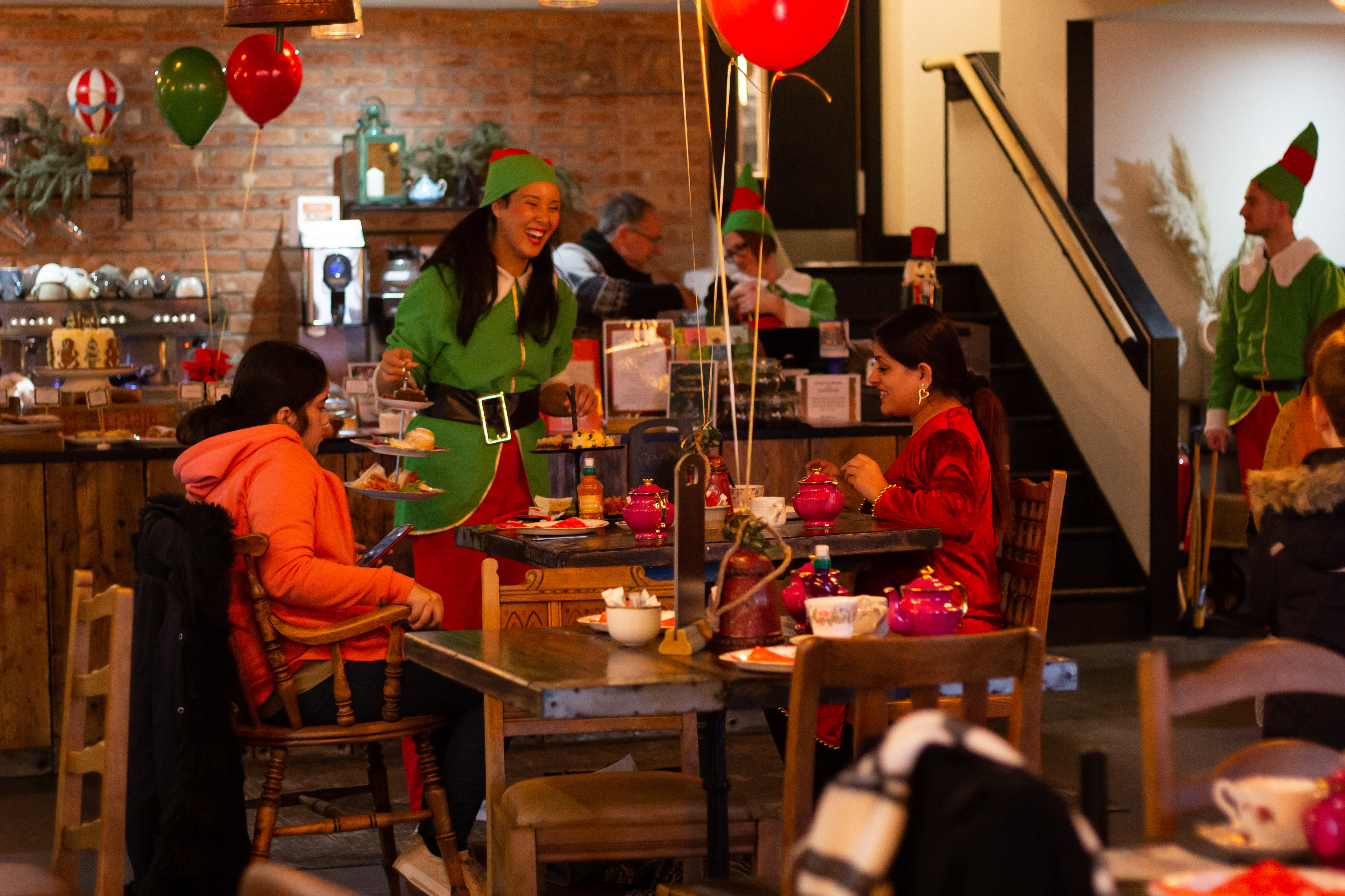 Festive Rising Cafe in Anchor Point with cheerful staff in elf costumes for holiday events.