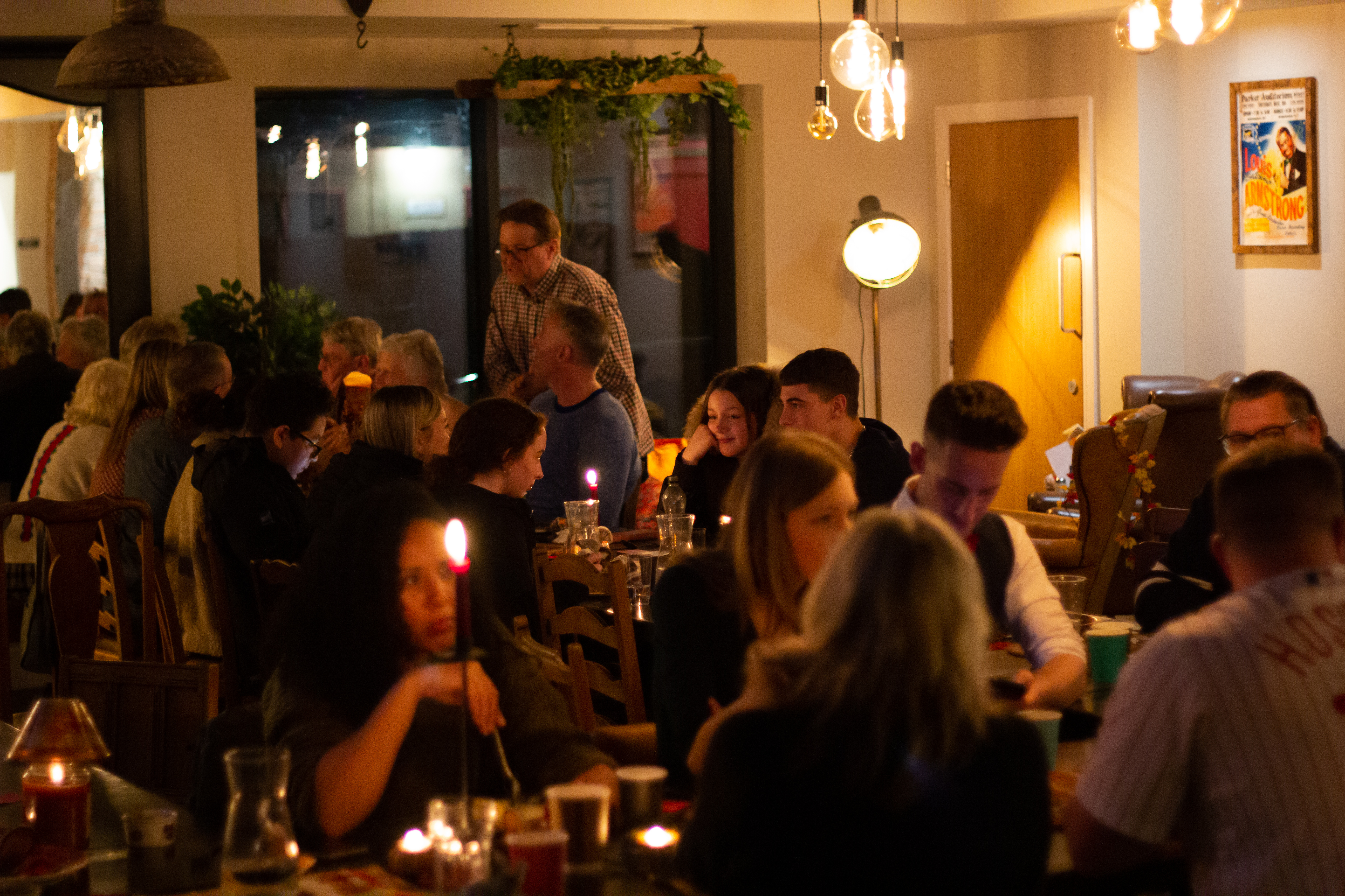 Vibrant networking event at Rising Cafe, cozy ambiance with candlelit tables.