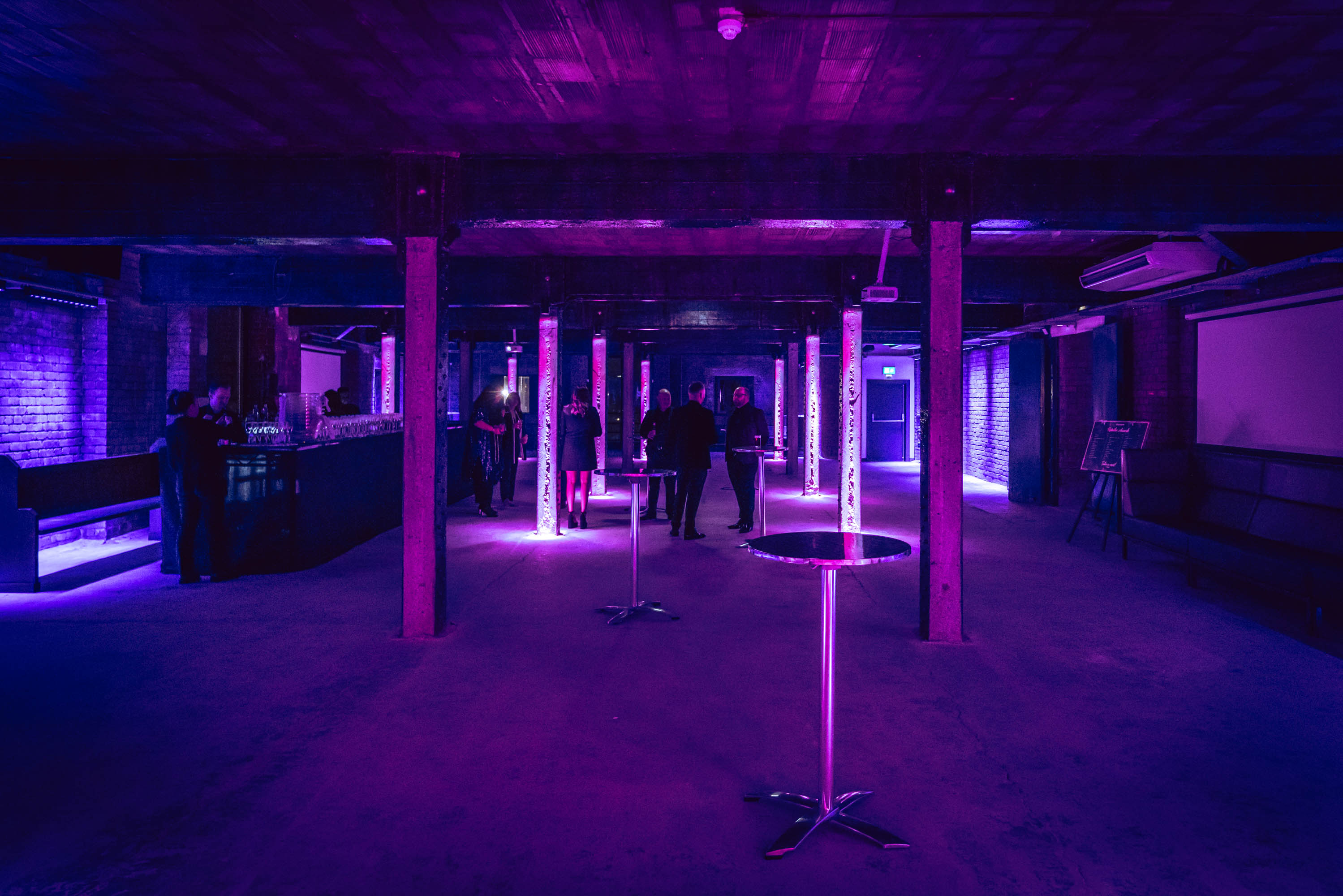 Modern event space at Tobacco Stores with purple lighting, perfect for corporate gatherings.