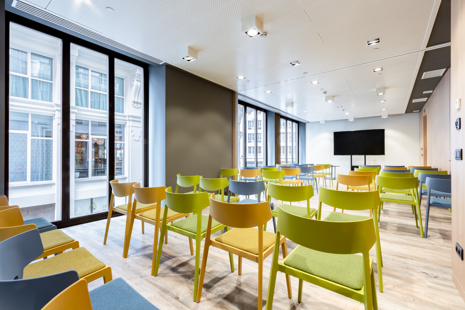 Modern meeting room with colorful chairs at Pestana CR7, ideal for workshops and collaboration.
