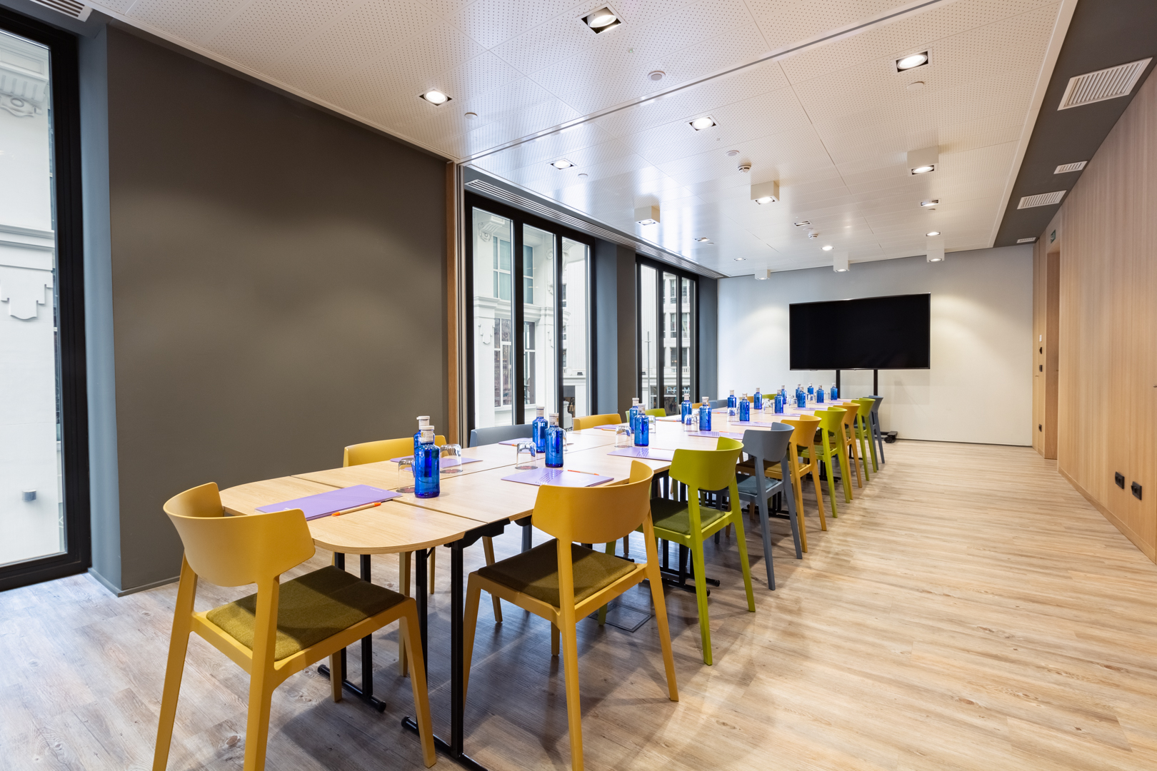 Modern meeting room with colorful chairs, ideal for workshops and brainstorming sessions.