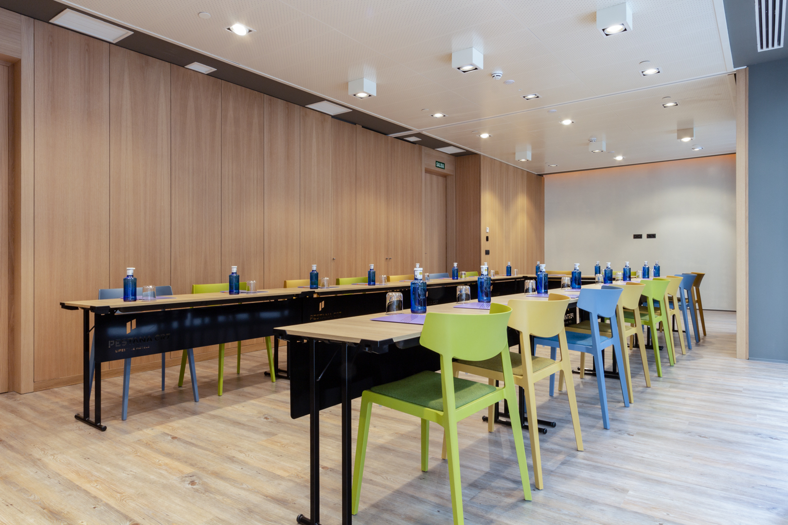 Modern meeting room with colorful chairs at Pestana CR7, perfect for workshops and brainstorming.