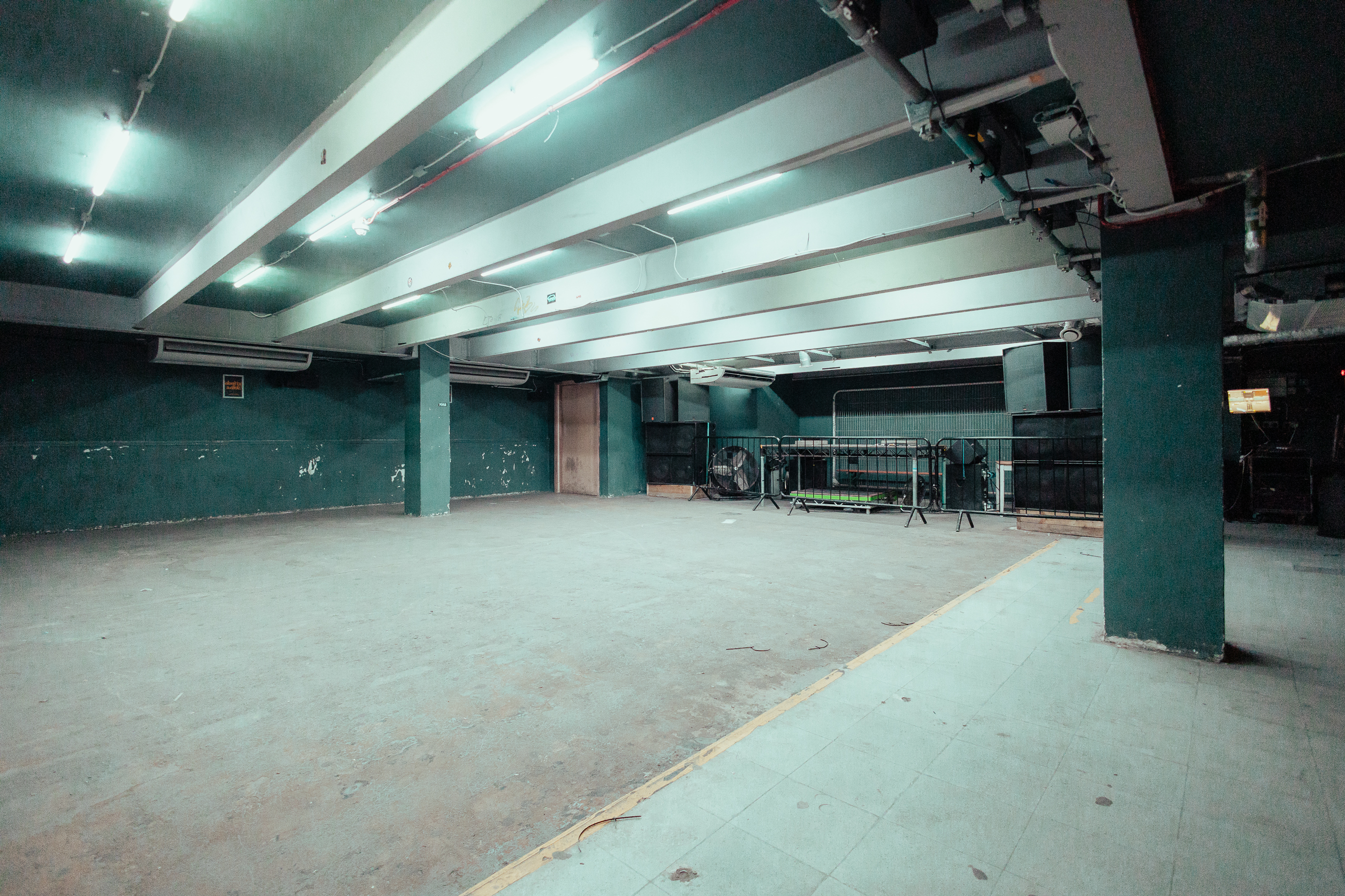 Spacious minimalist event venue with exposed beams, ideal for customizable gatherings.