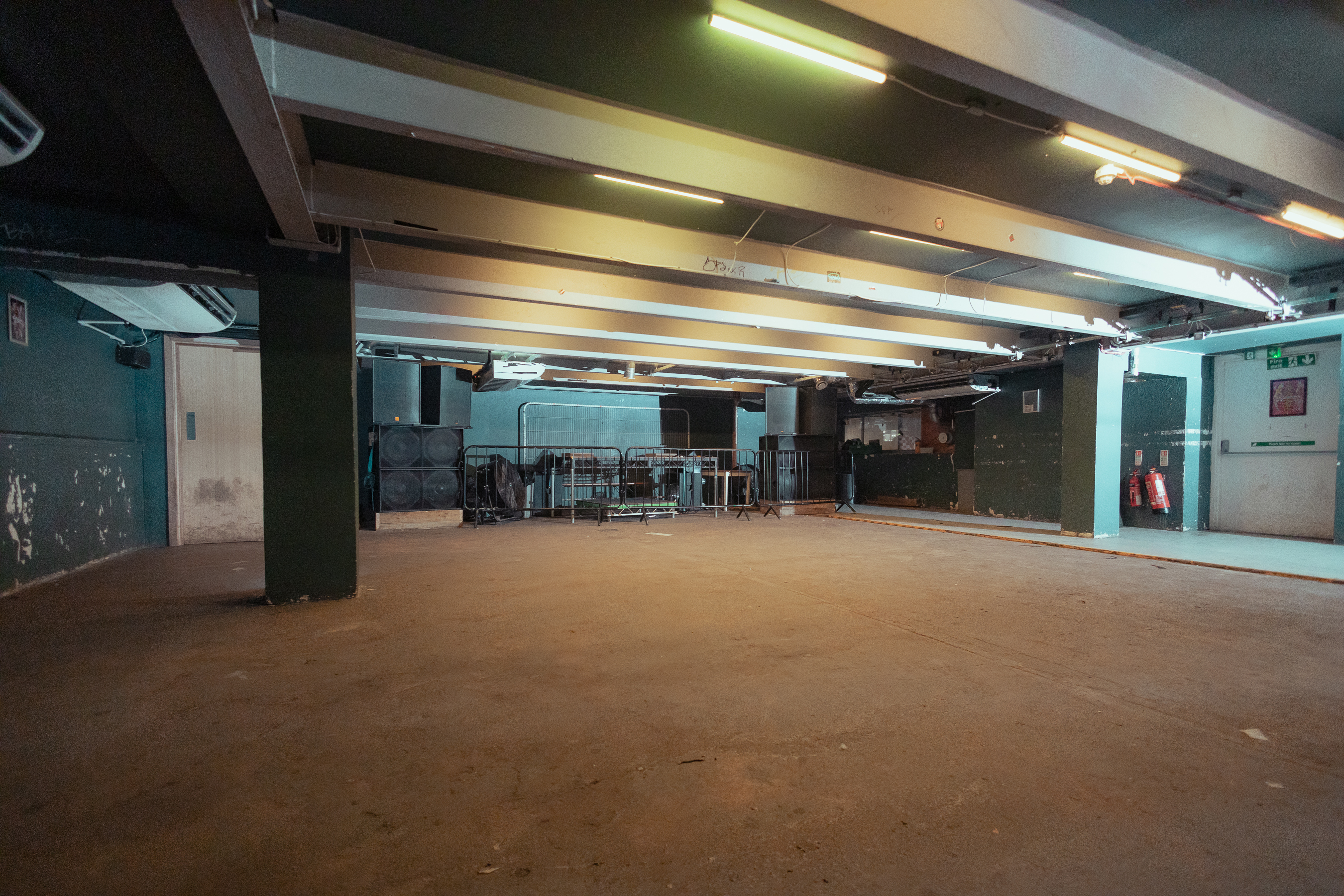 Spacious unfinished venue with exposed beams for customizable events at The Cause.