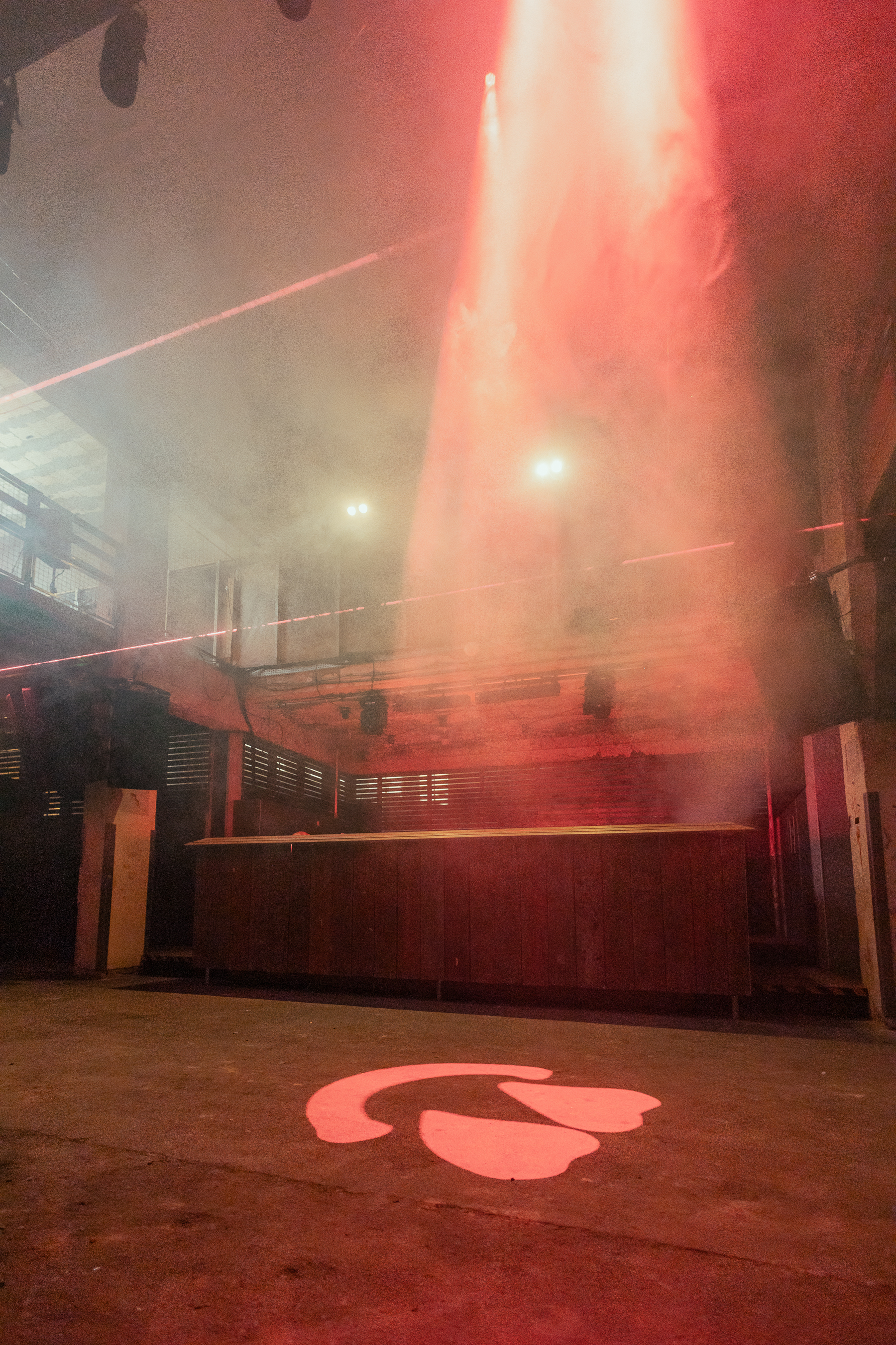 Versatile industrial event space with bar, fog, ideal for parties and immersive experiences.