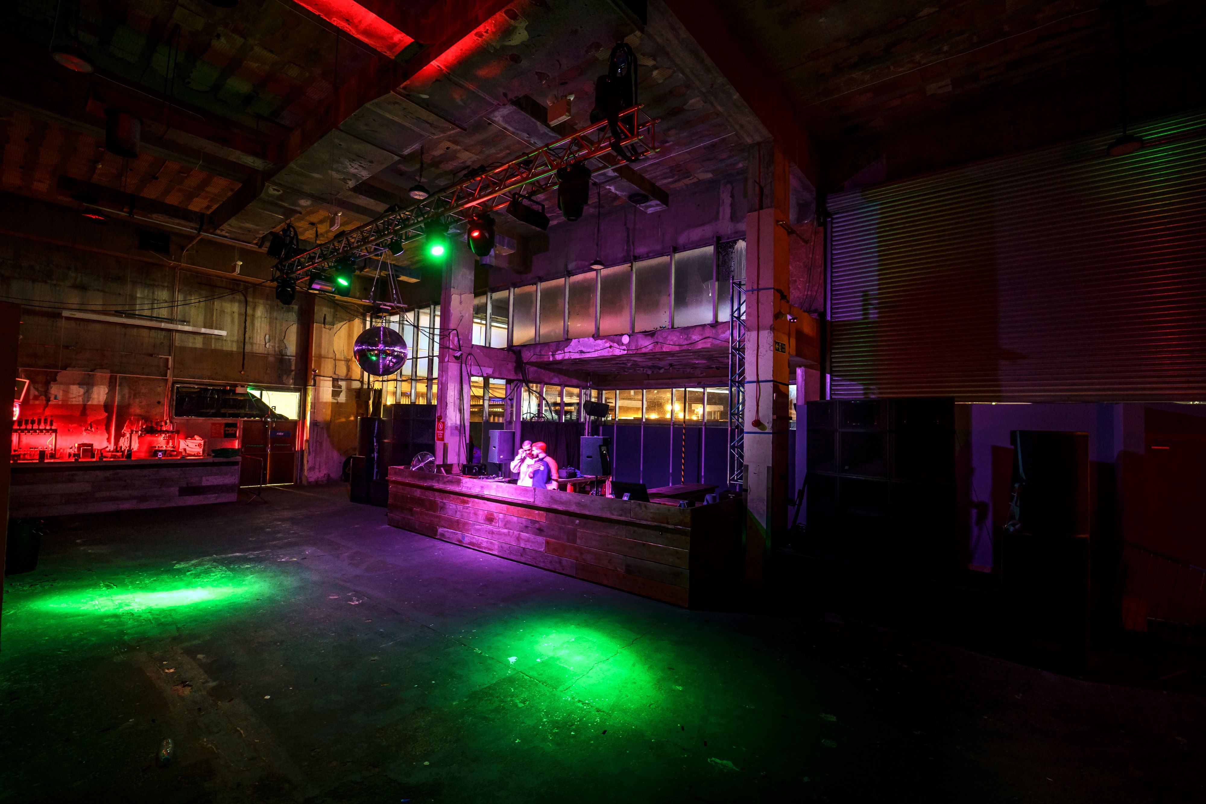 Versatile industrial event space with dramatic lighting for corporate and social gatherings.