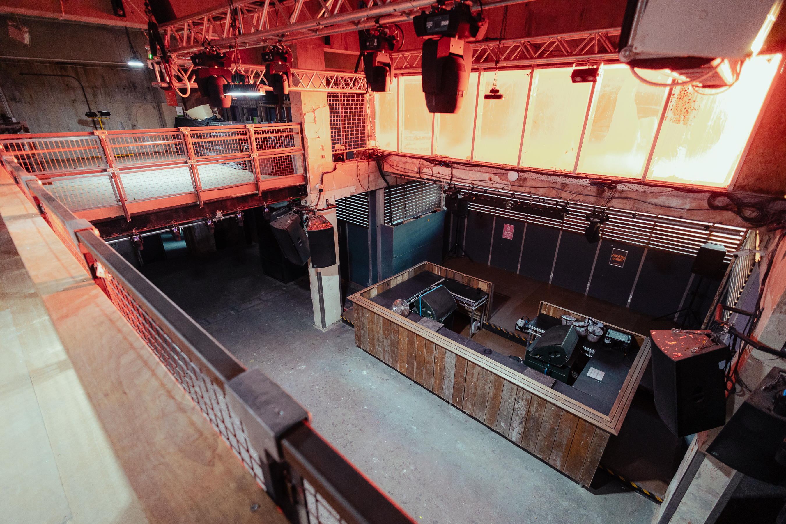 Versatile industrial event space with central stage for corporate and creative gatherings.