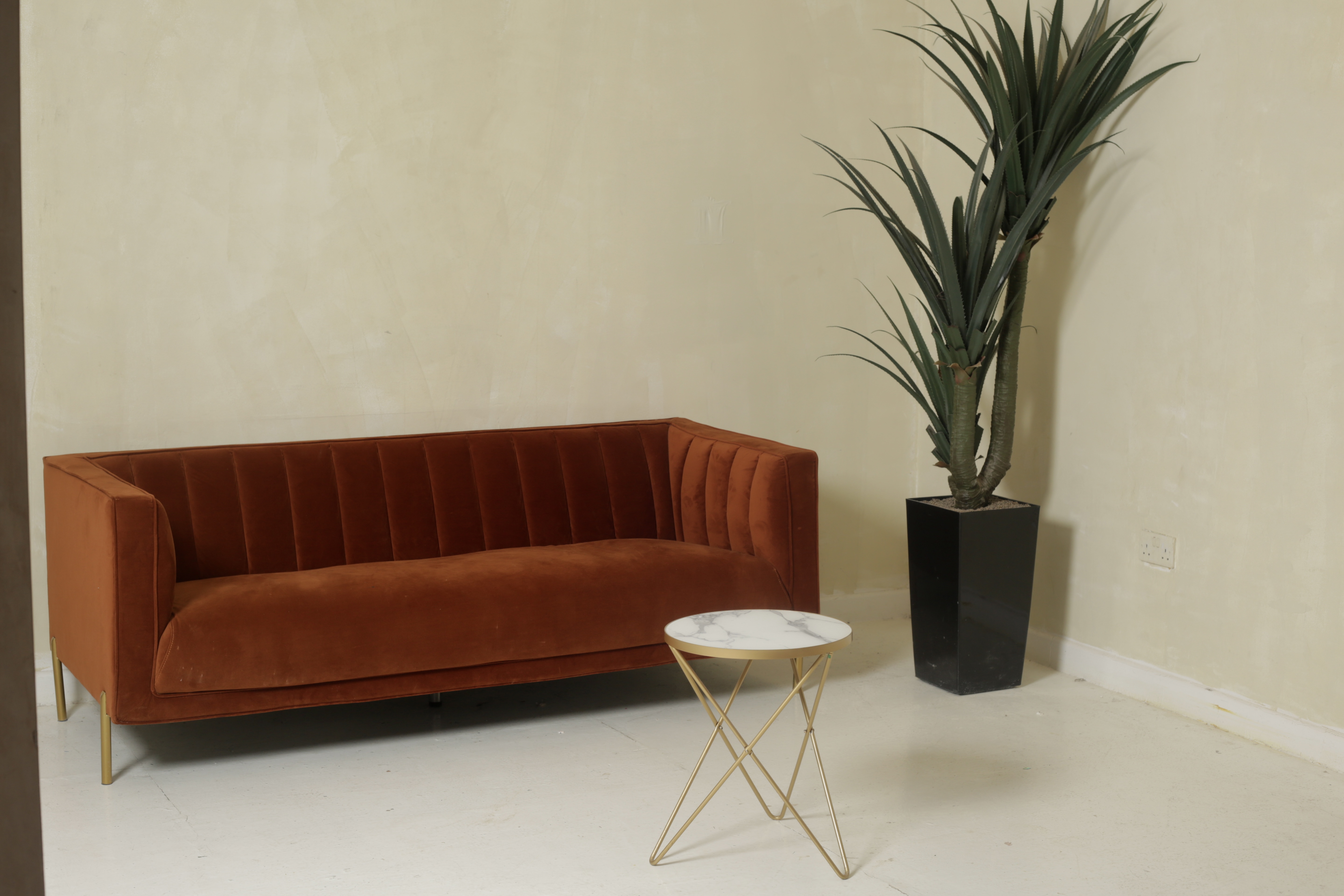 Stylish lounge with rust sofa and marble table, ideal for modern meetings and networking.