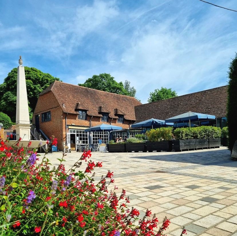 Charming outdoor venue at Coach House Kitchen, ideal for events and meetings with blue umbrellas.