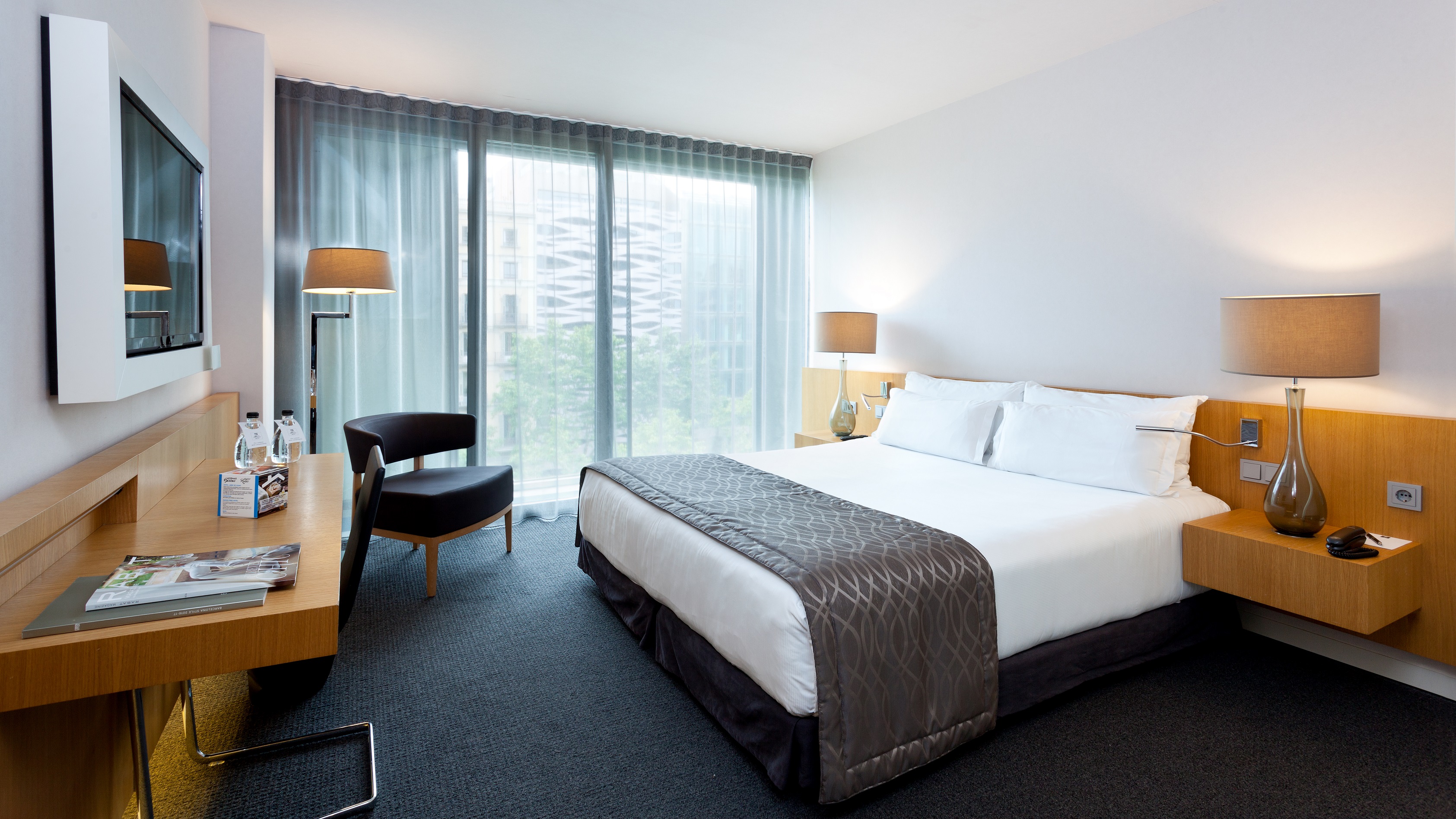 Modern hotel meeting room with king-sized bed, ideal for business events and remote work.