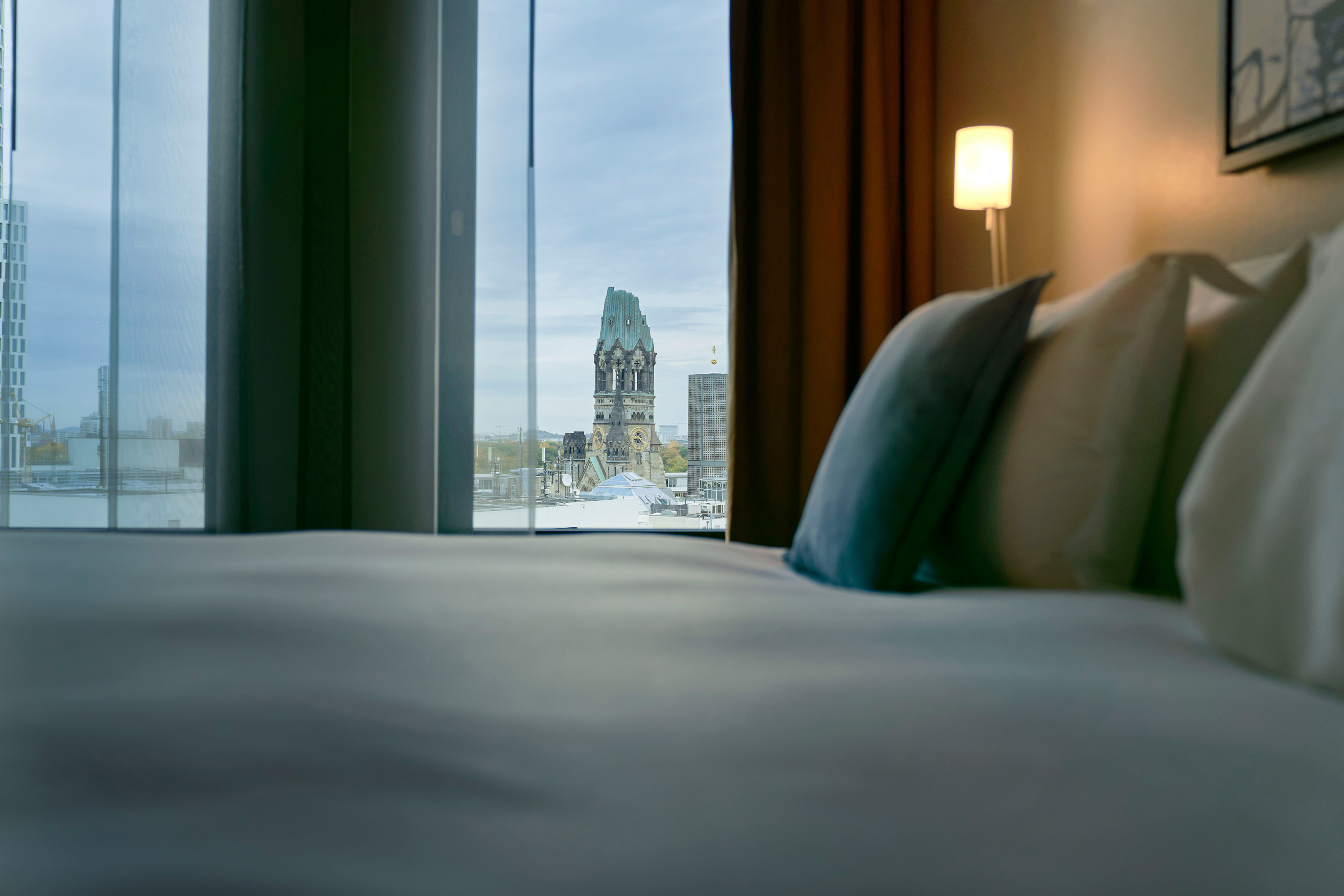 Dorint Kurfürstendamm Berlin hotel room with cozy bed, ideal for business events and relaxation.