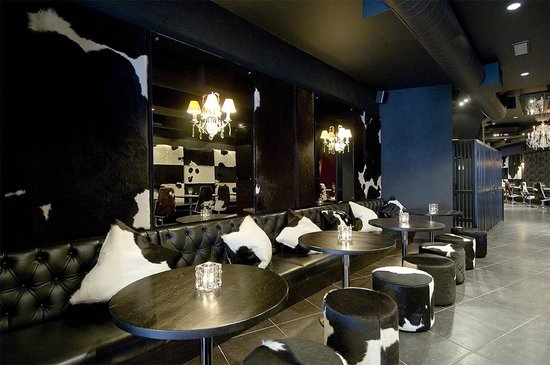 Stylish event space in Hampstead with sleek black furnishings and elegant chandeliers.