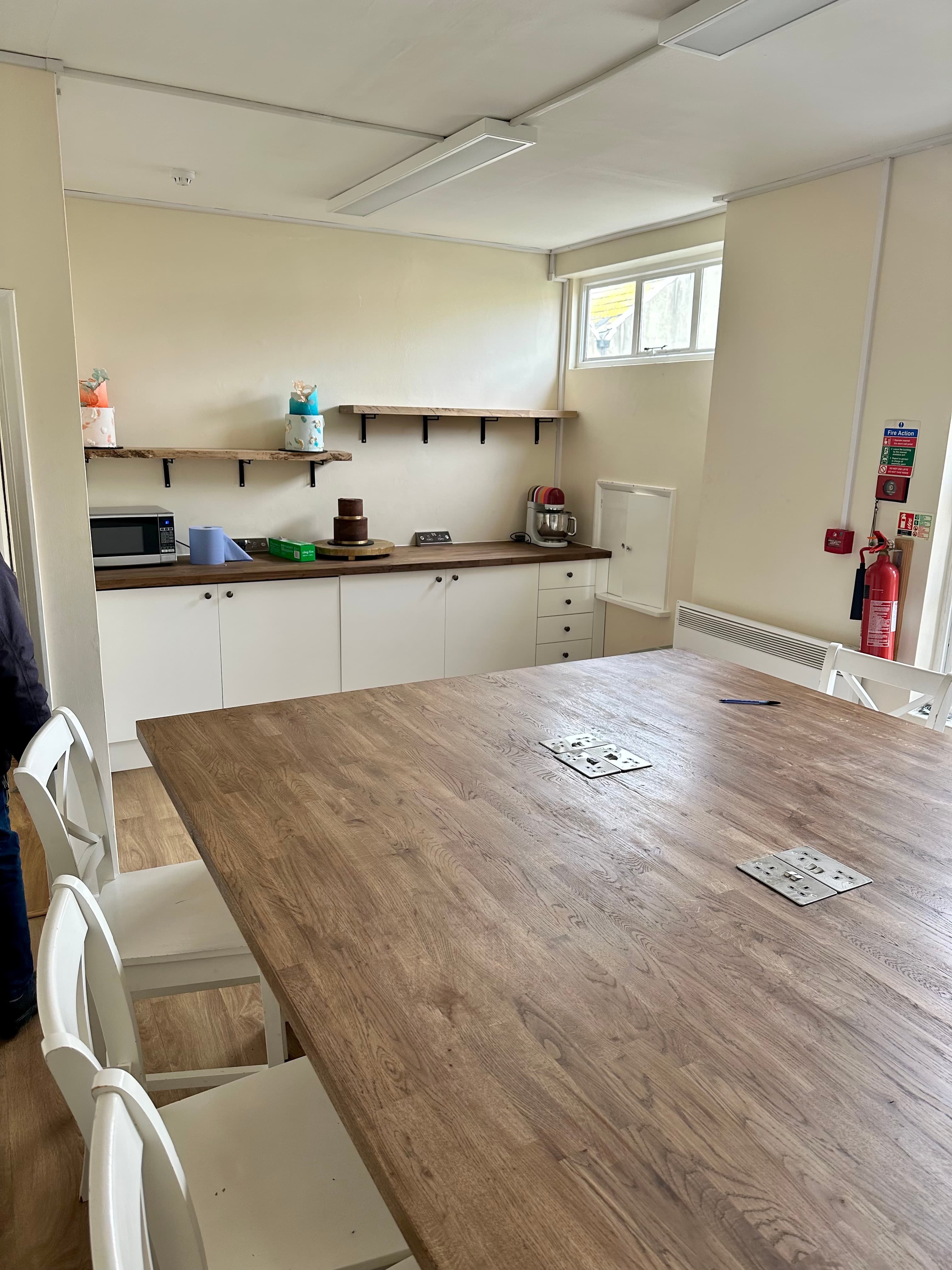 Bright meeting space with large wooden table, perfect for workshops and team meetings.
