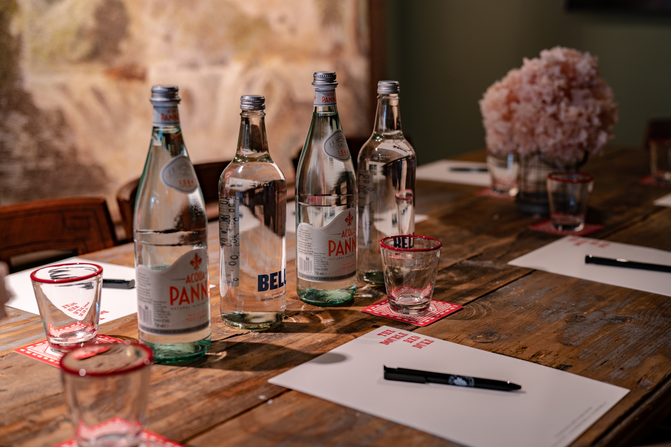 Elegant meeting setup in Feasting Room with floral accents and sparkling water.