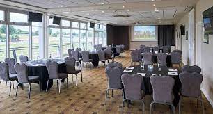Corporate event space at Warwick Racecourse with round tables and natural light.