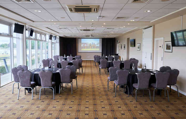 Elegant event space at Warwick Racecourse with round tables for corporate meetings.