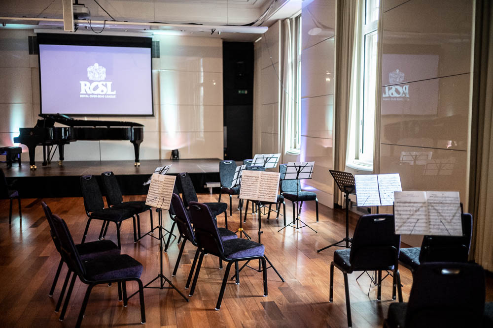 Princess Alexandra Hall setup for a musical event with chairs, piano, and projection screen.