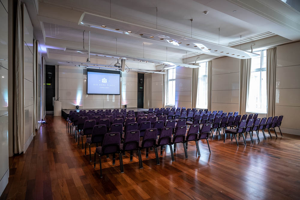 Princess Alexandra Hall event space with purple chairs, ideal for conferences and presentations.