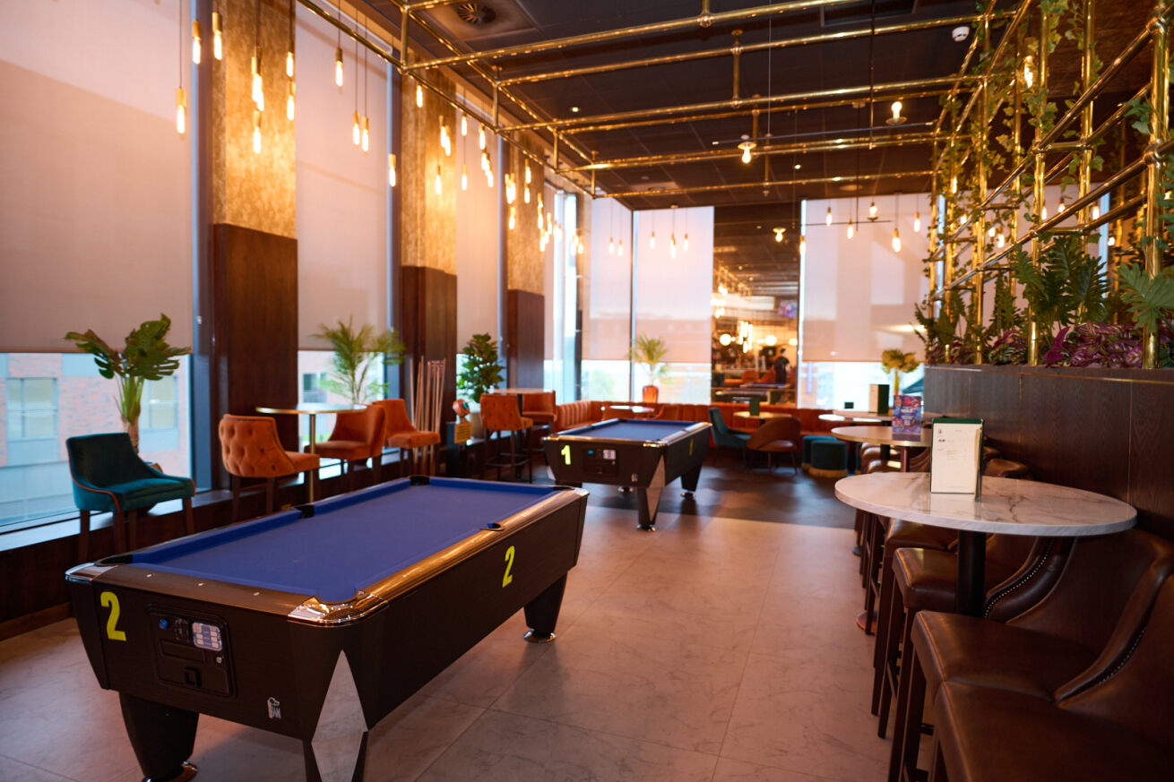 Stylish event space at Newton's Bar, featuring pool tables for casual networking.