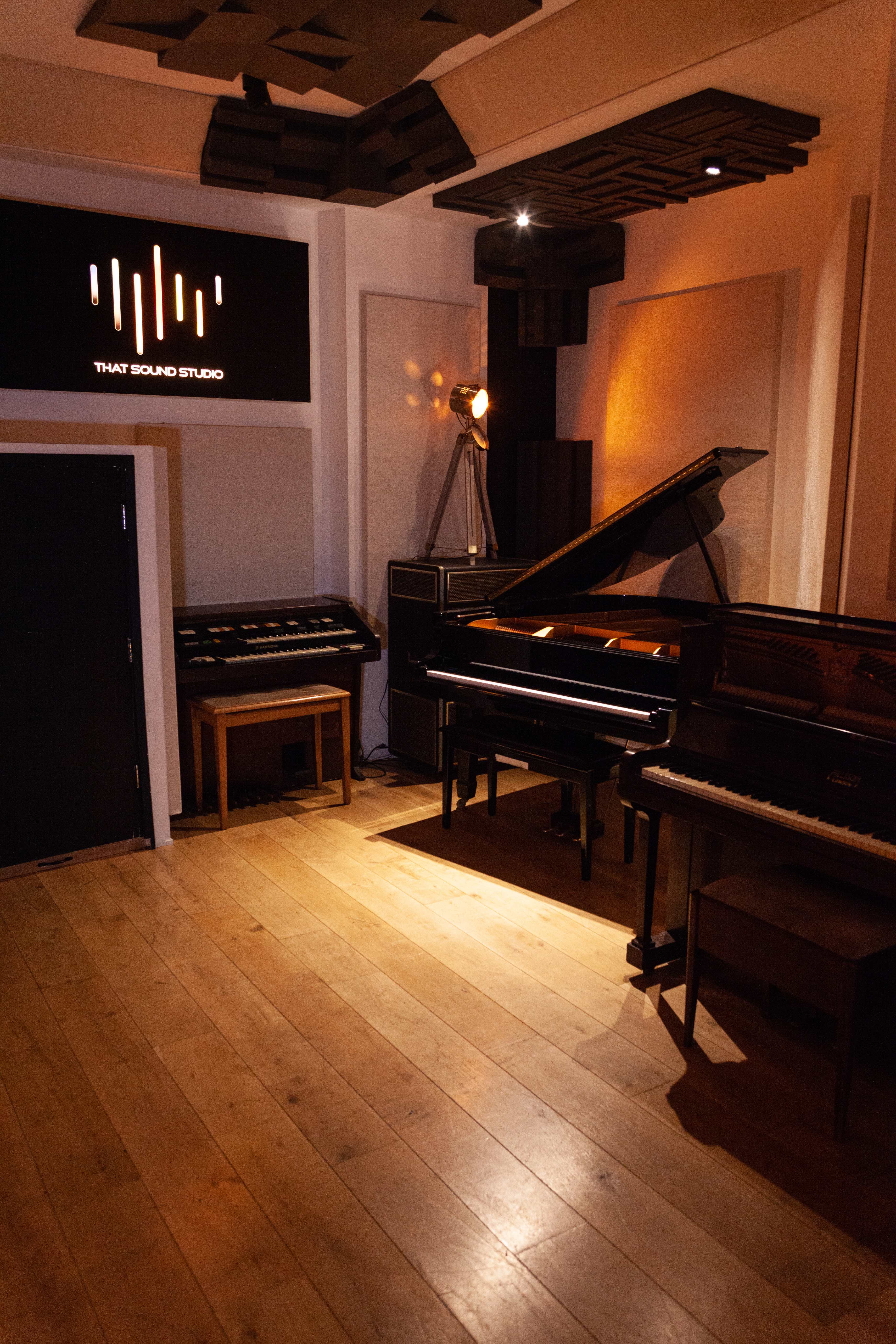Recording studio with pianos, warm lighting for exclusive events and workshops.