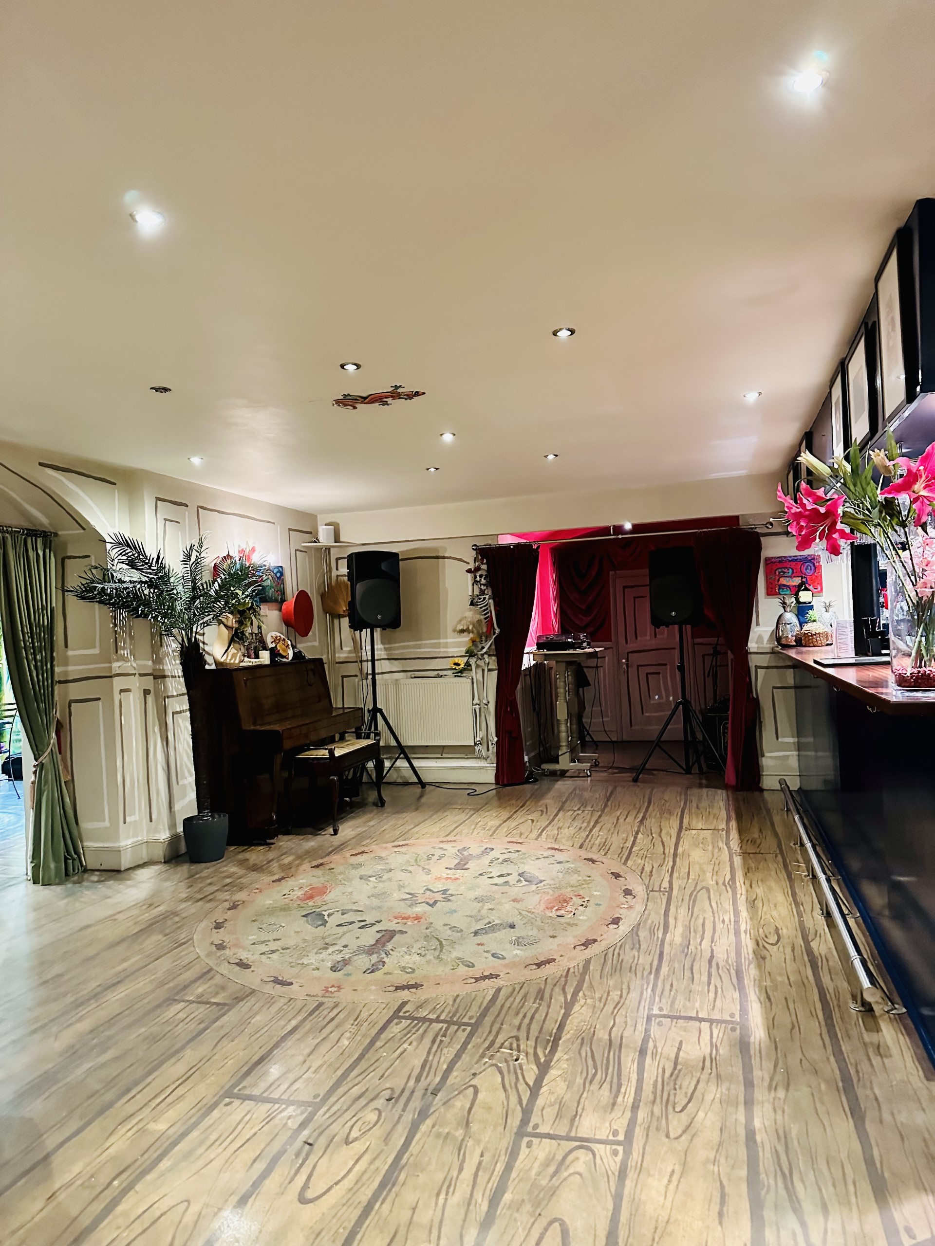 Versatile event space with wooden piano, ideal for live performances and gatherings.