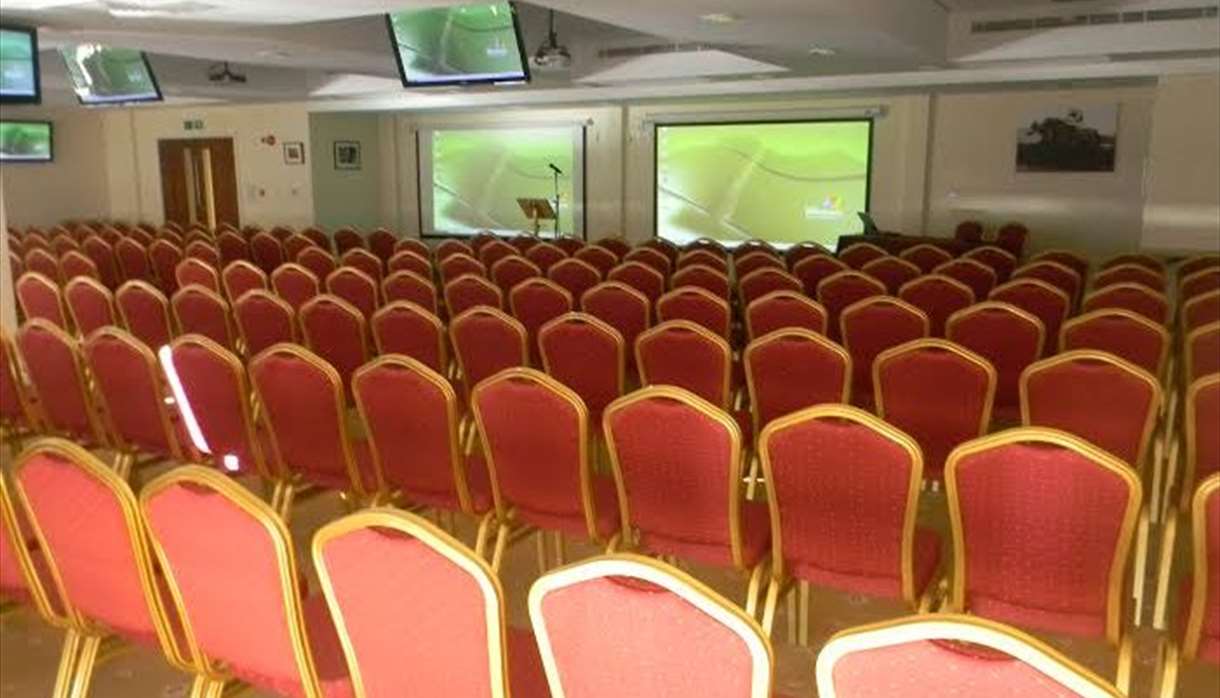 Exeter Racecourse conference room with red chairs for corporate presentations.