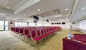 Exeter Racecourse meeting space with red chairs, ideal for conferences and presentations.