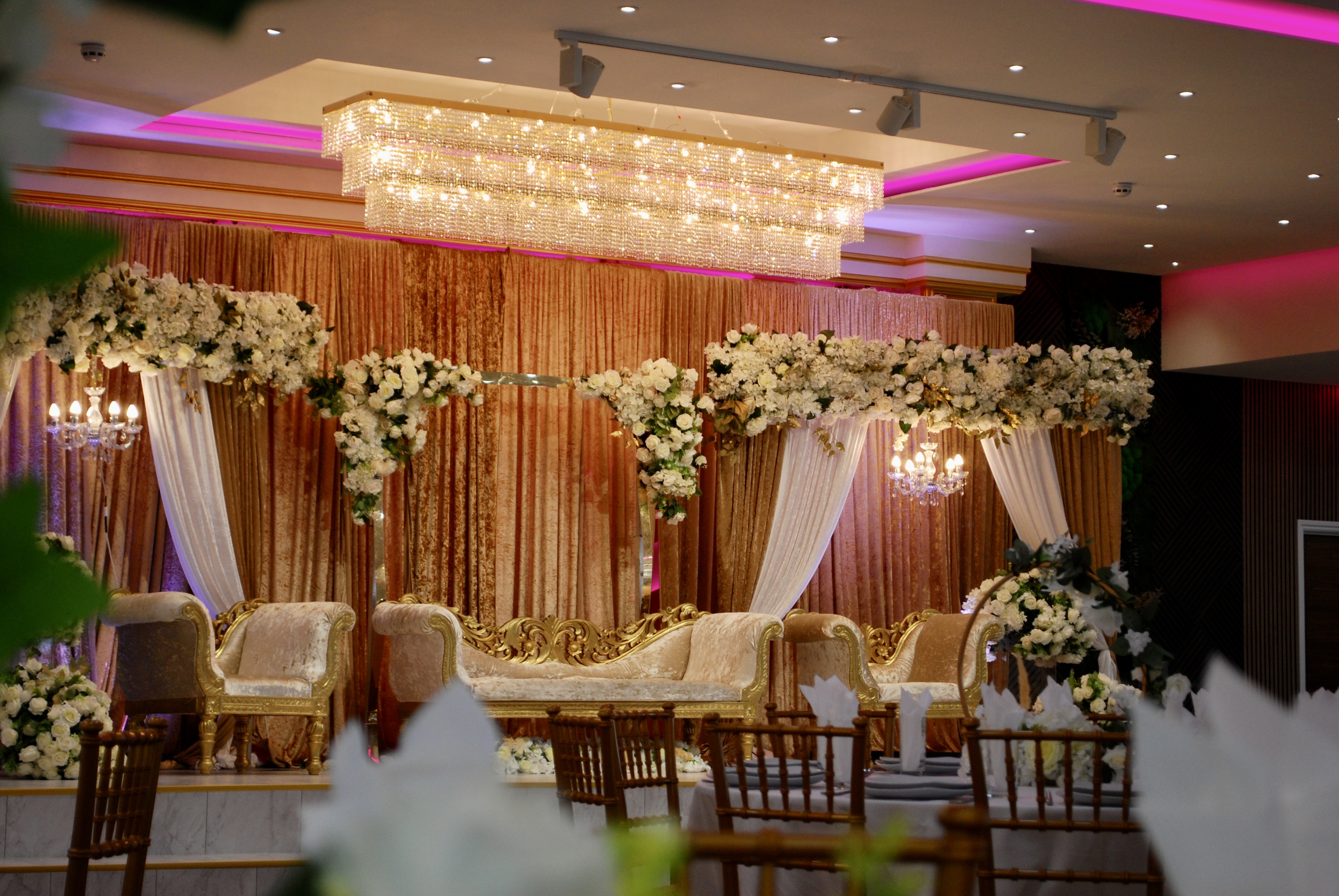 Elegant Main Hall in Crystal Suite with floral backdrop, ideal for weddings and upscale events.