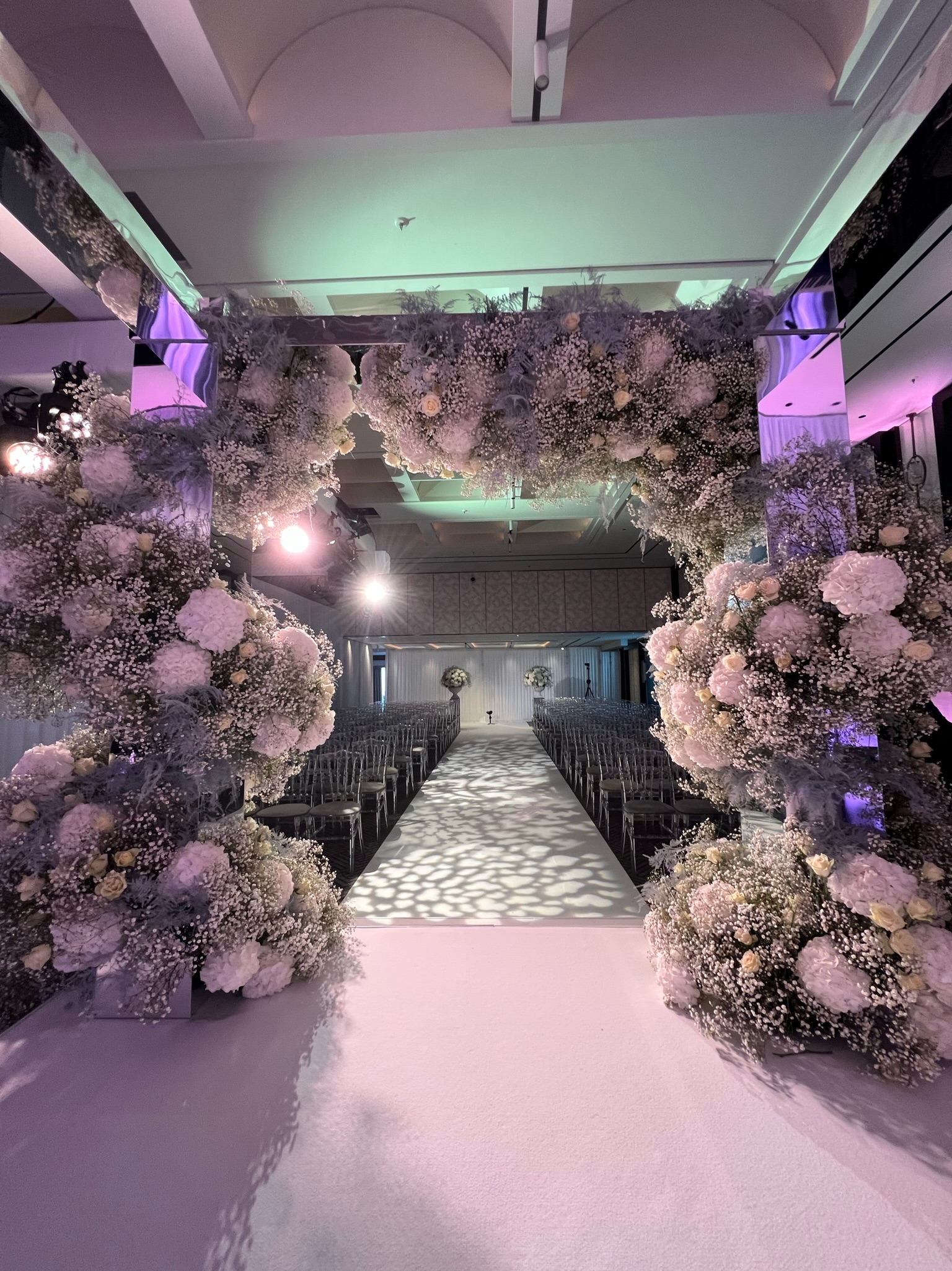 Elegant ballroom at Nobu Hotel with floral arch, perfect for weddings and upscale events.
