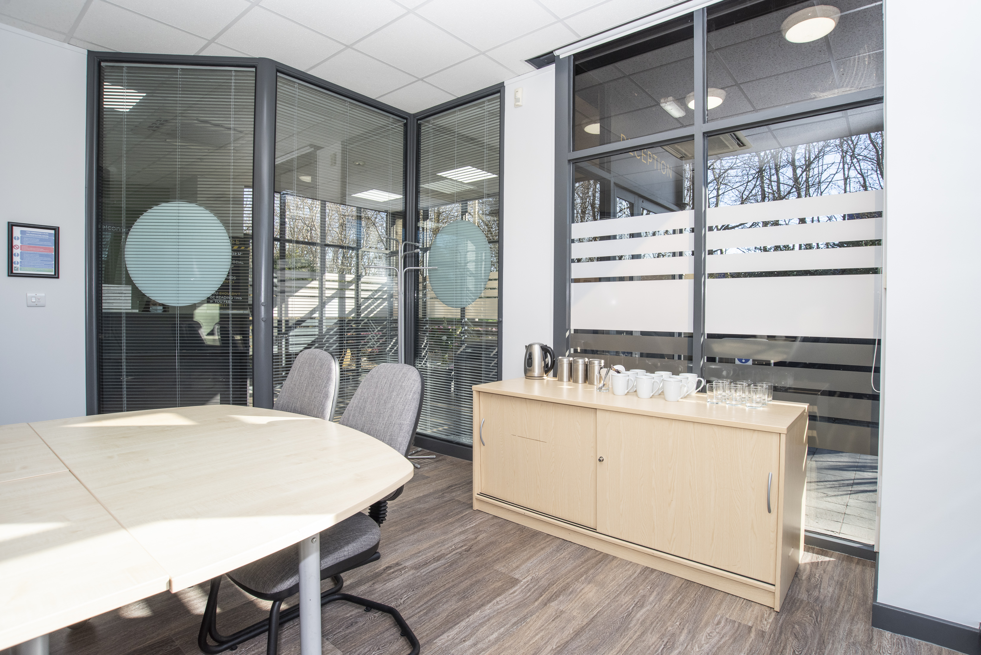 Modern meeting room with round table and glass walls for collaborative events.