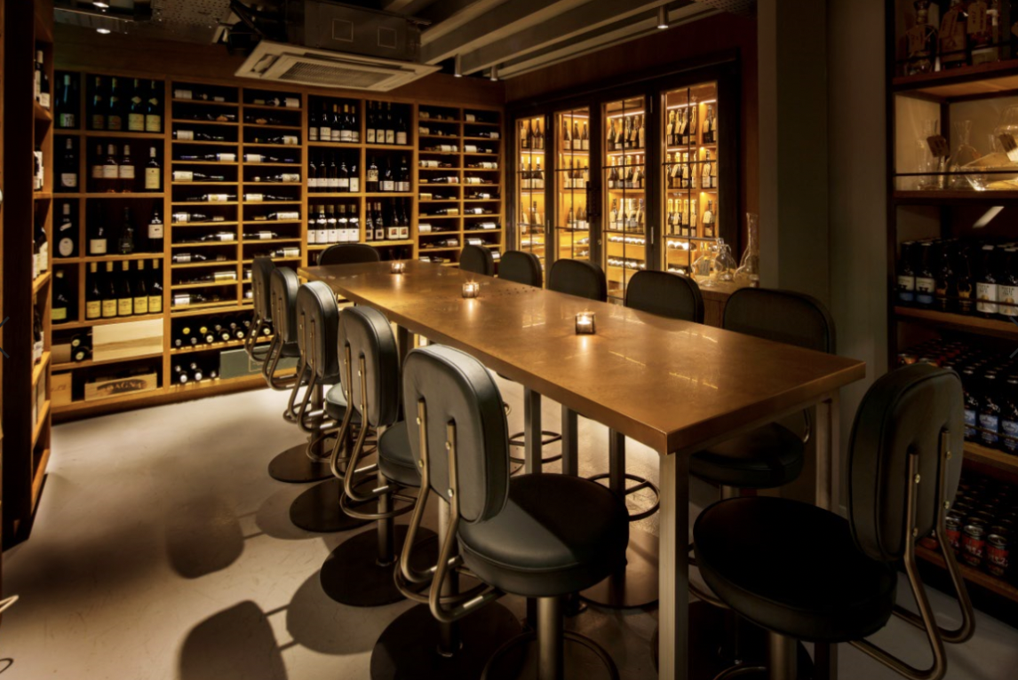 Intimate wine cellar with wooden table for private meetings and exclusive events.