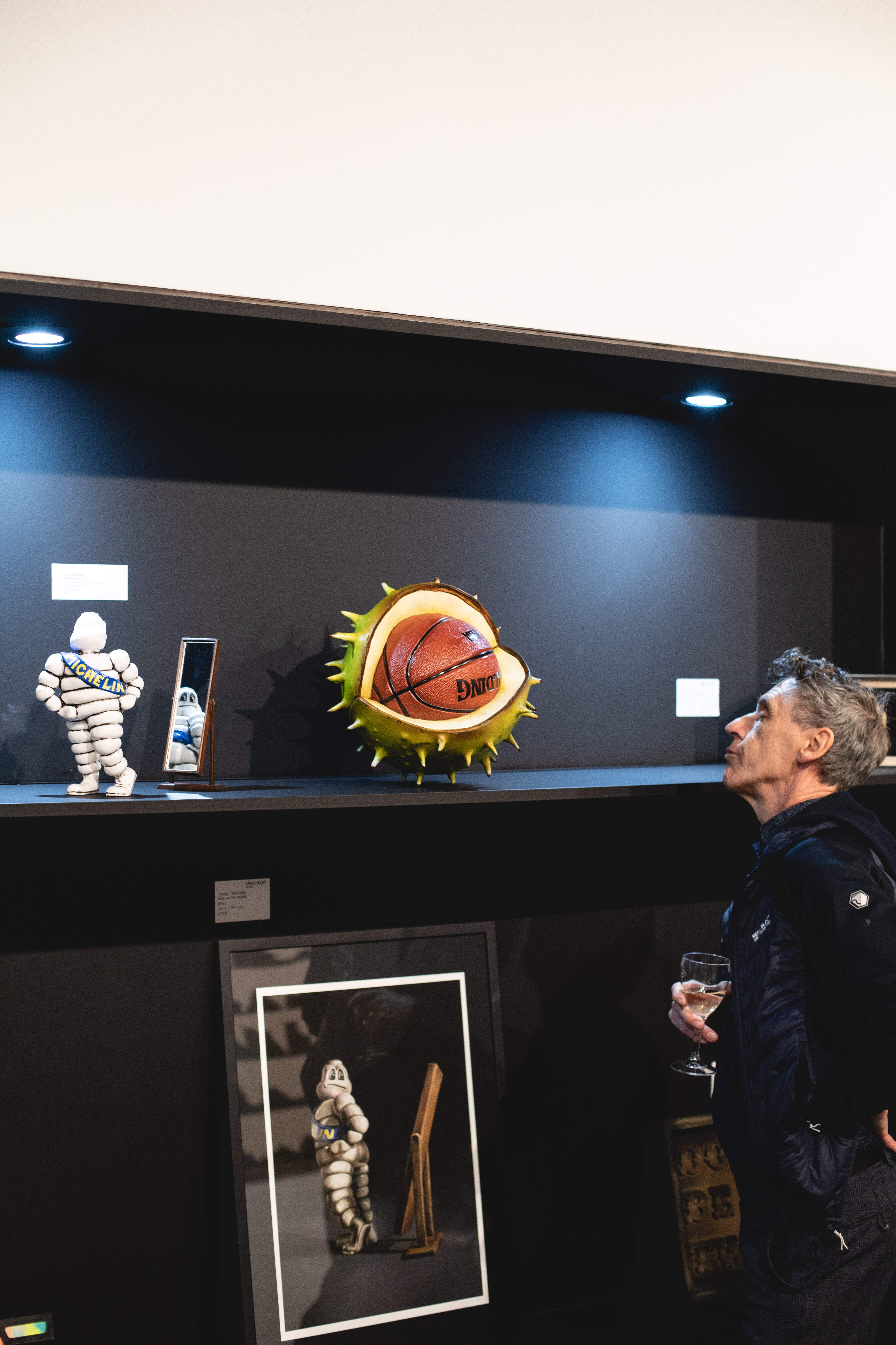 "Basketball sculpture and Michelin Man at Smolensky Gallery art event in Manchester."