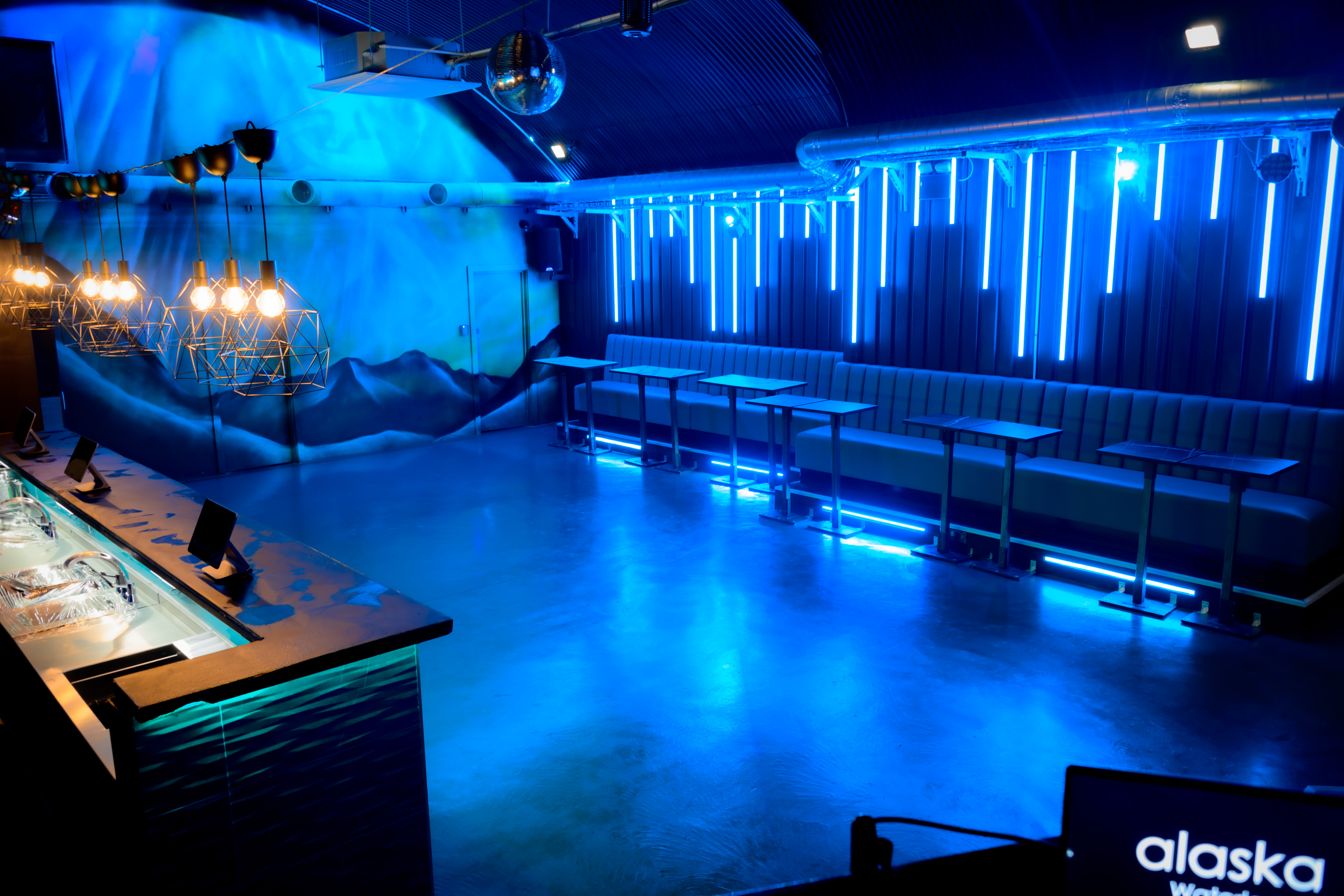 Modern event space in Alaska with vibrant blue lighting for networking and cocktail receptions.