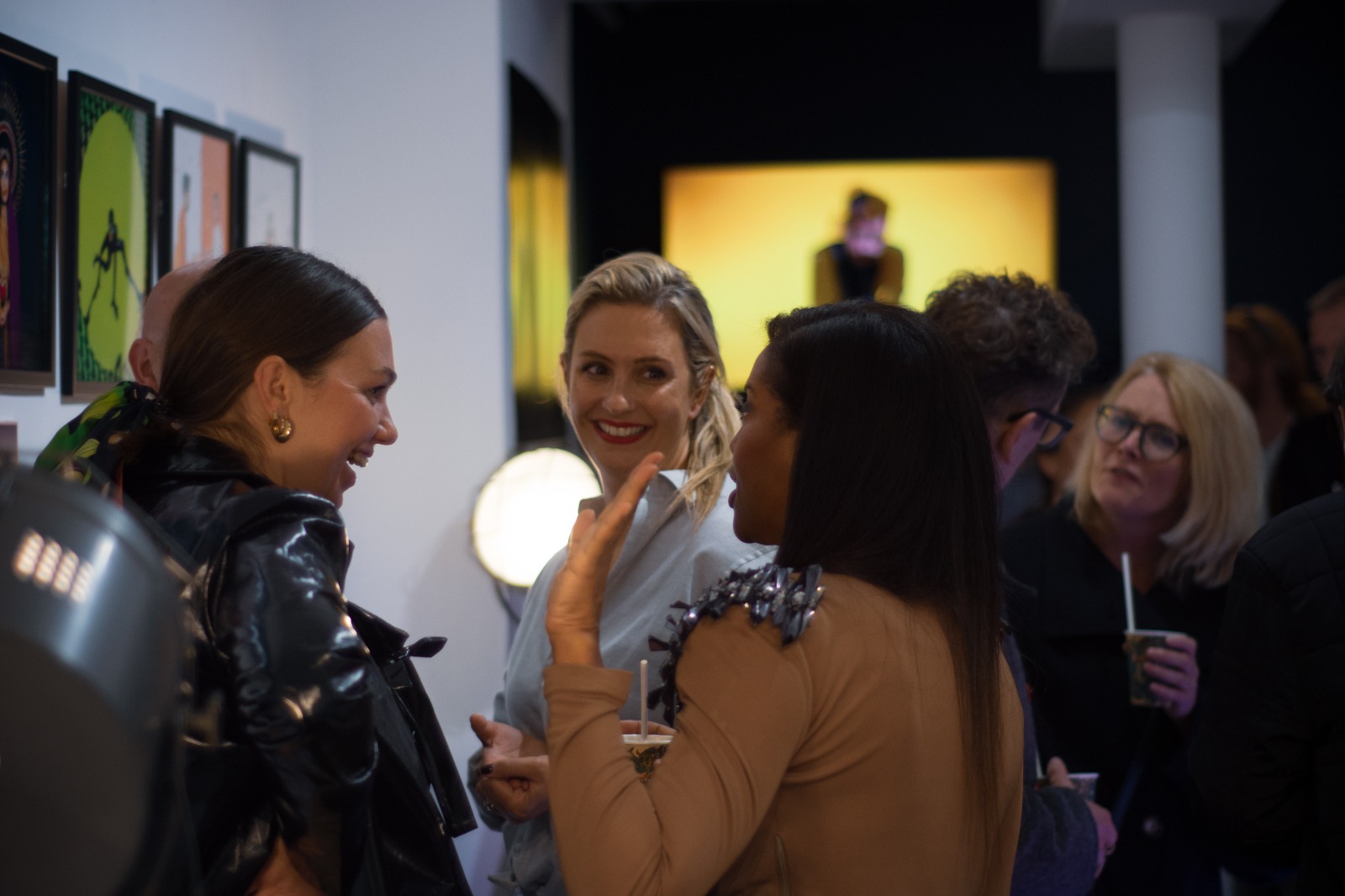 Vibrant networking event at Proud Galleries with attendees engaging in conversation.