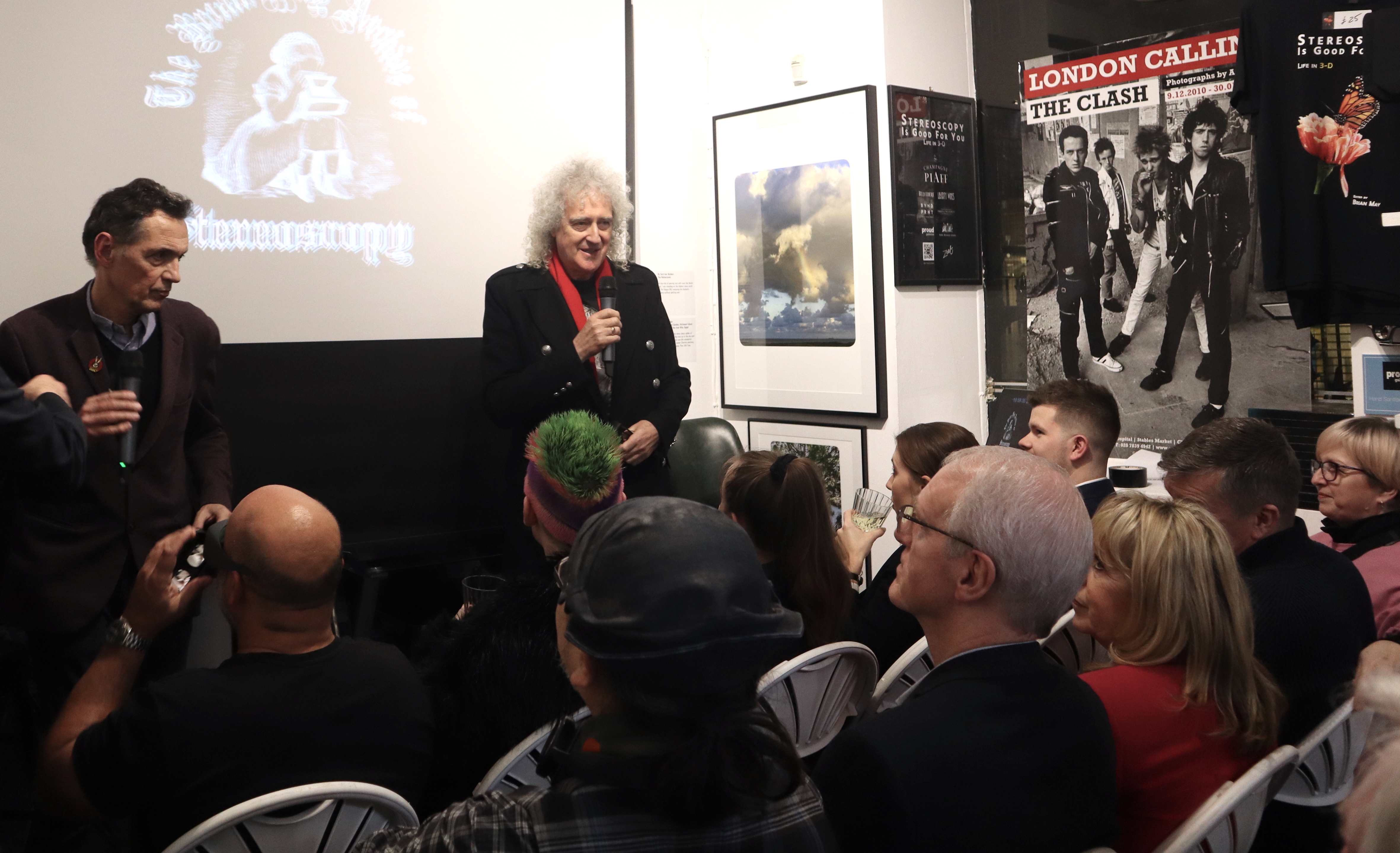 Engaging speaker at dynamic event in Proud Galleries with creative backdrop and interactive seating.