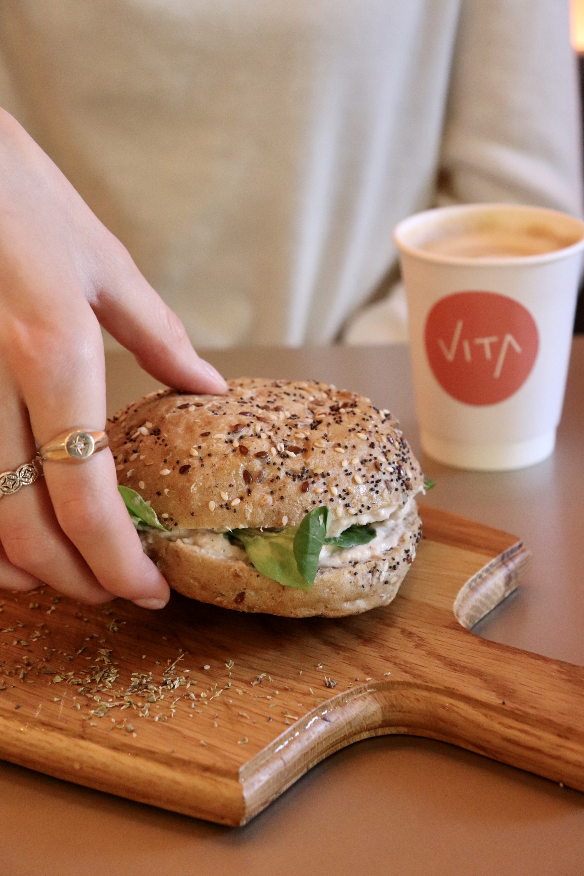 Hand reaching for a wholesome sandwich at Vita Cafe, ideal for event catering and branding.