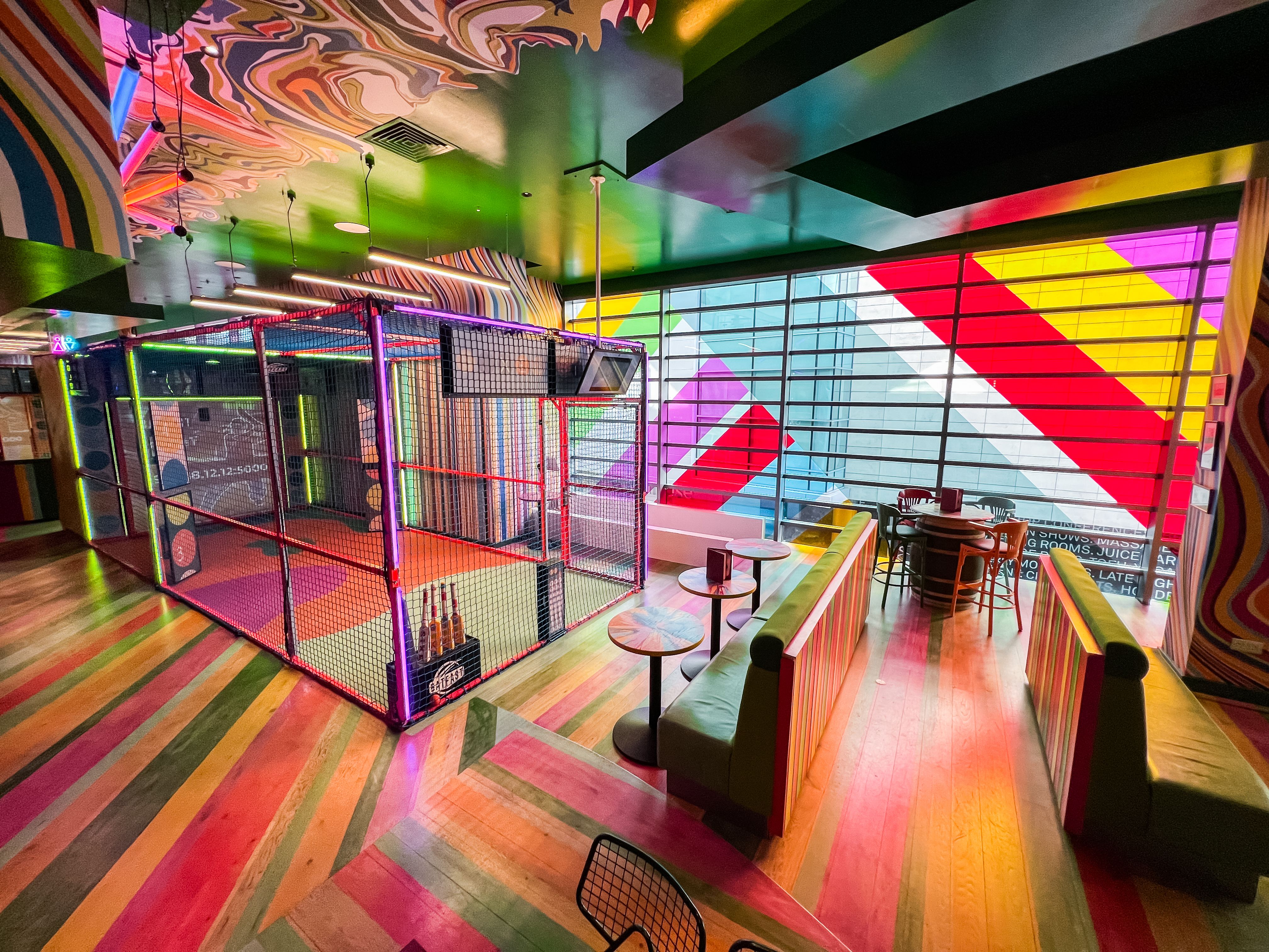 Vibrant event space with colorful decor and batting cage for gatherings in Shepherd's Bush.