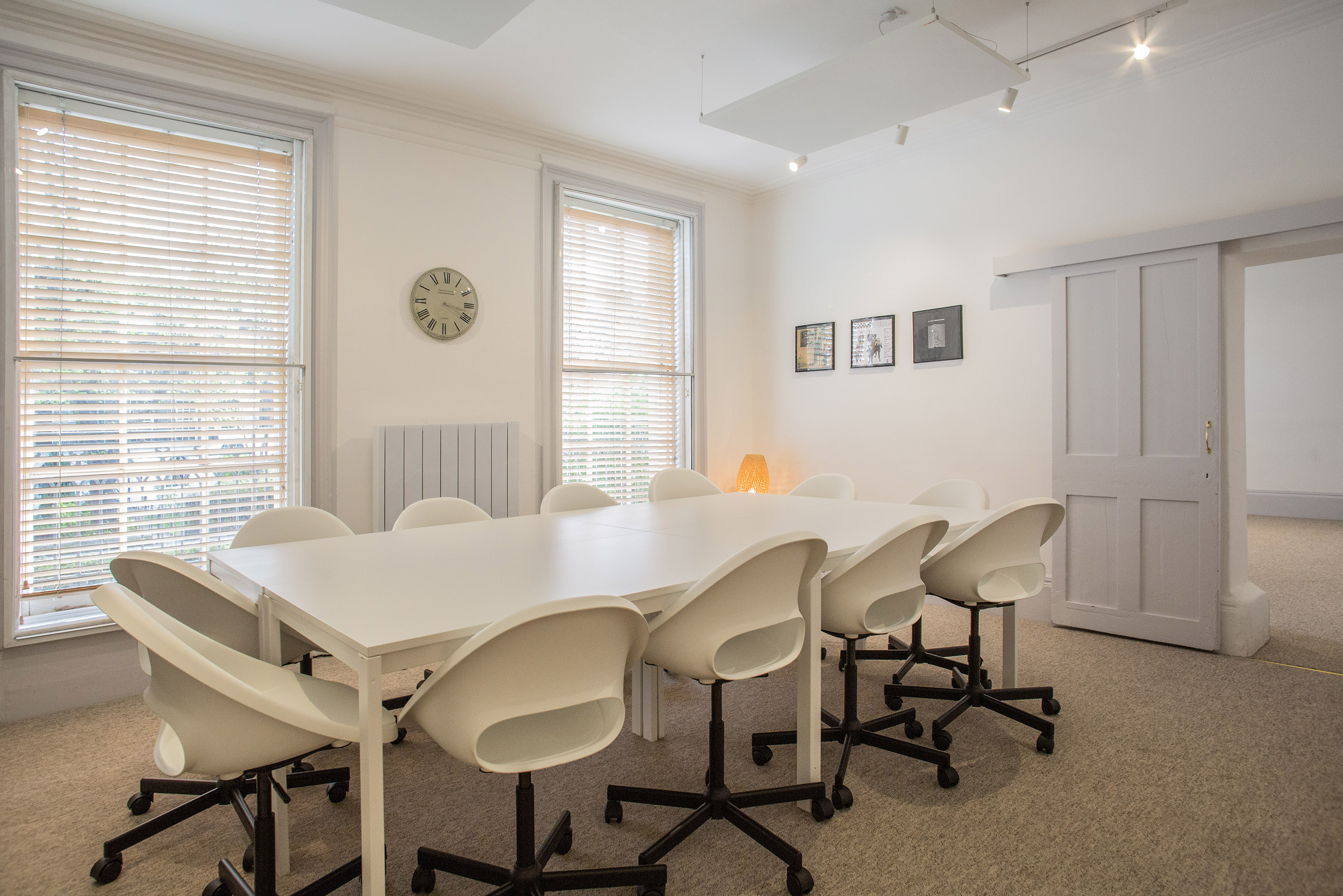 Well-lit meeting room with large white table, ideal for brainstorming sessions.