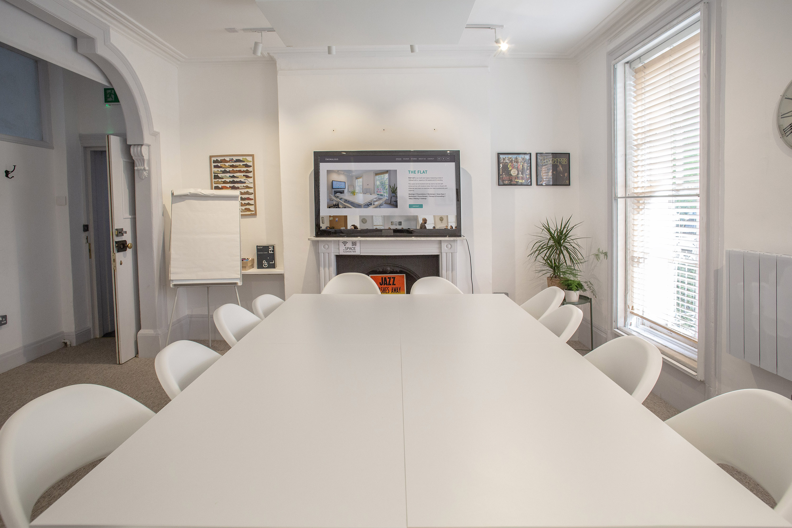 Modern meeting room with large white table, ideal for workshops and strategy sessions.