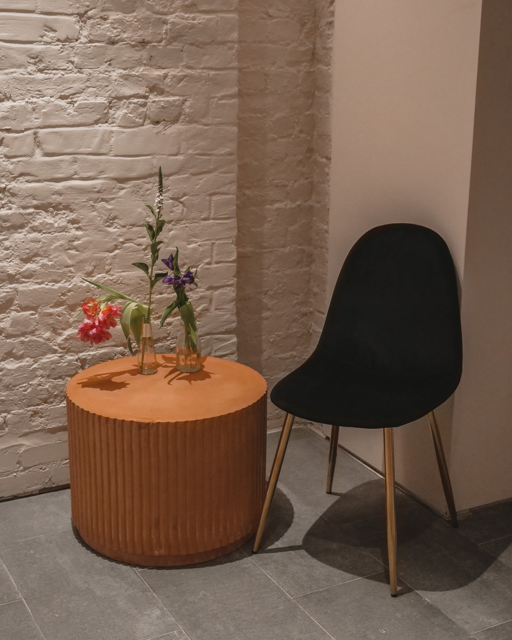 Stylish corner setup with orange table and black chair for intimate meetings at Vita Boutique Fitness.